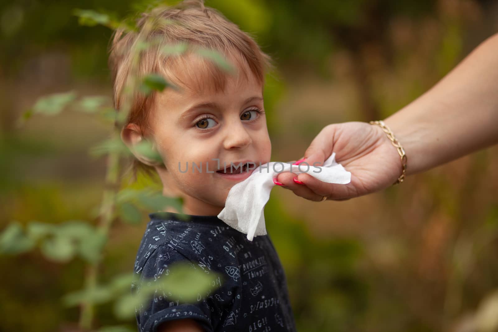 Hygiene - mom wiping the baby face skin with wet wipes. Cleaning wipe, pure, clean, outdoor