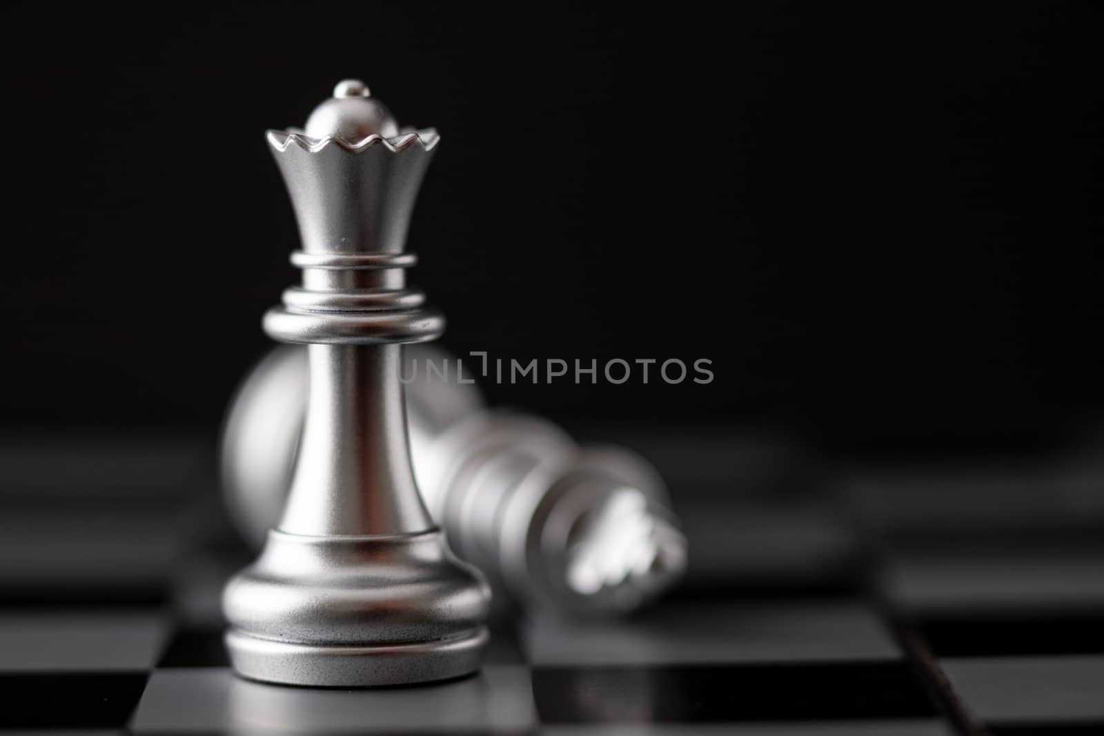 Silver king and queen in game on the chessboard by Nikkikii