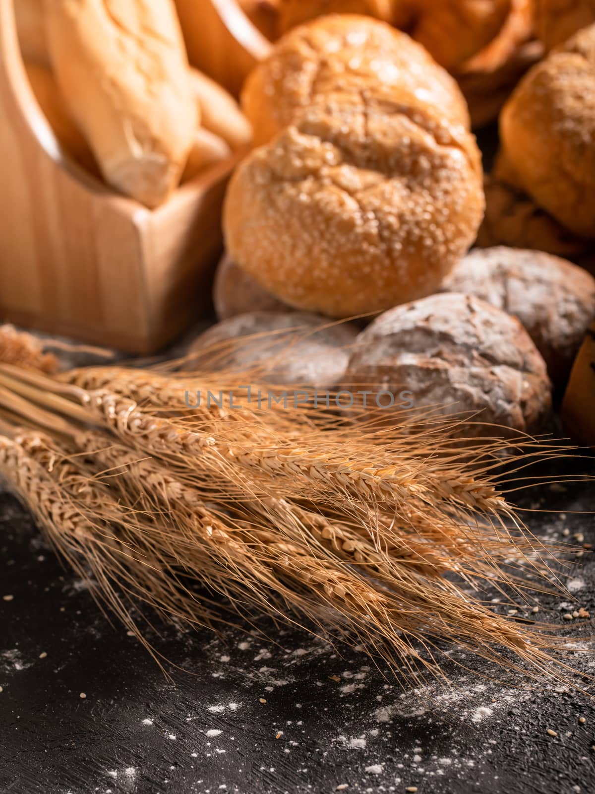 wheat and group bread on the black wooden table by Nikkikii