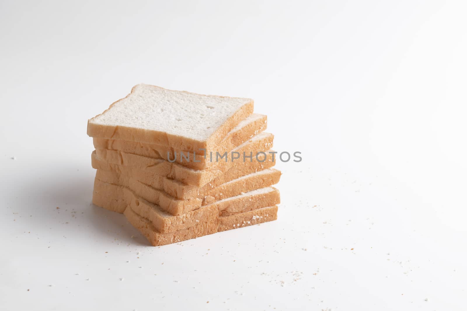 Slice of bread on the white background. Breads are a food made from wheat flour mixed with water and yeast or baking powder.