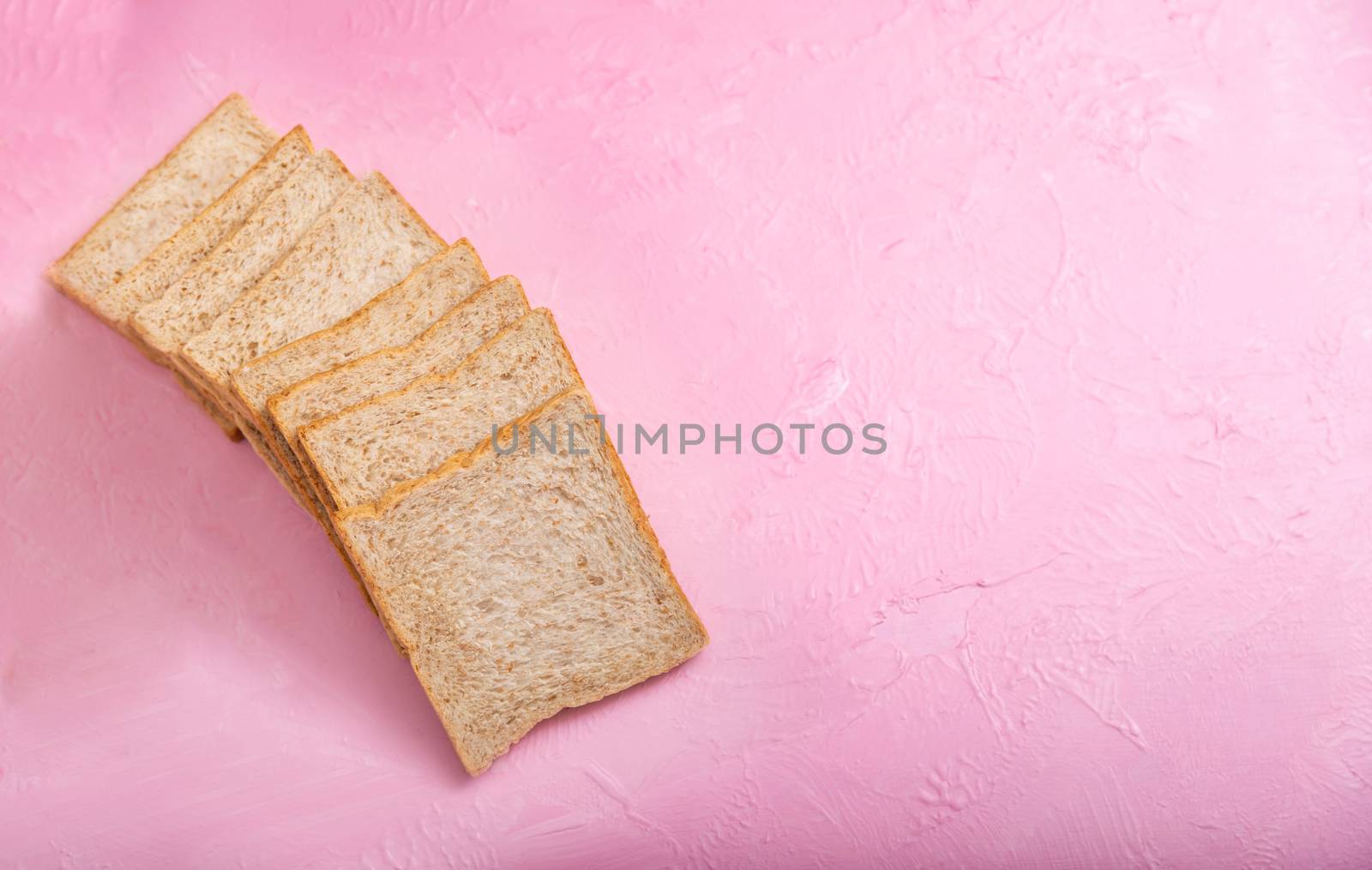 Bread slice isolated on color background. Bakery on the wooden pink backgrounds and texture.