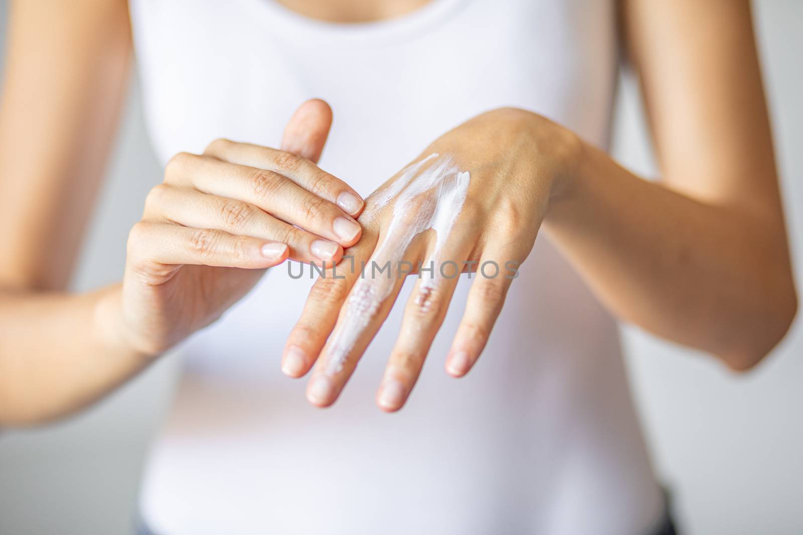 Woman applying hand cream - stock photo by adamr