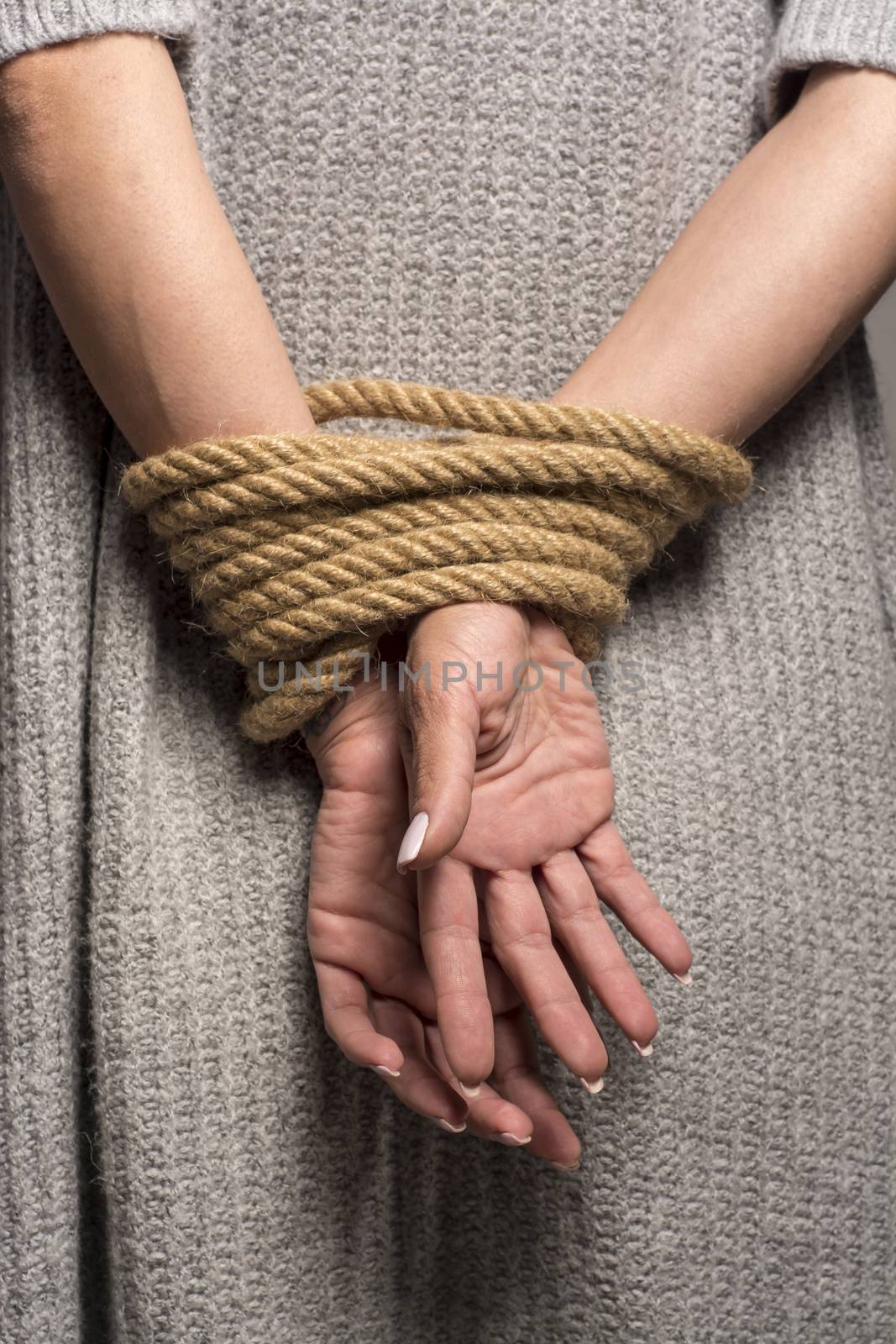 Womans hands on back tied with a rope, long nails