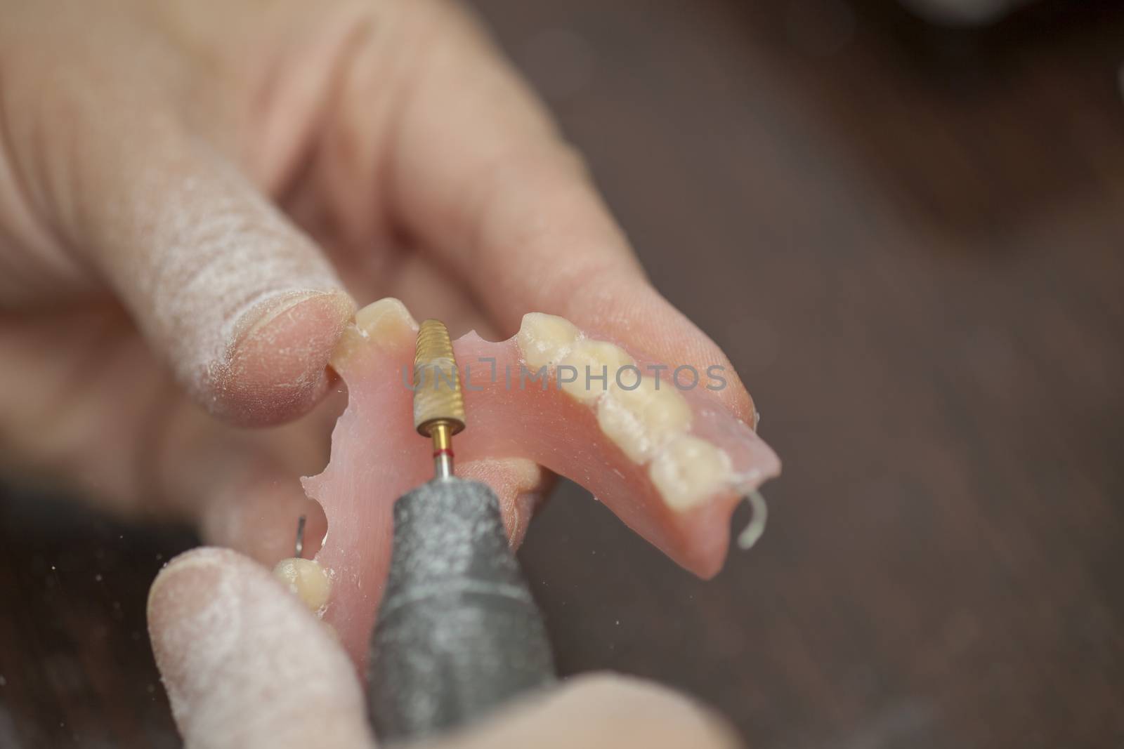 Dental technician make prothesis denture in dental laboratory, close up