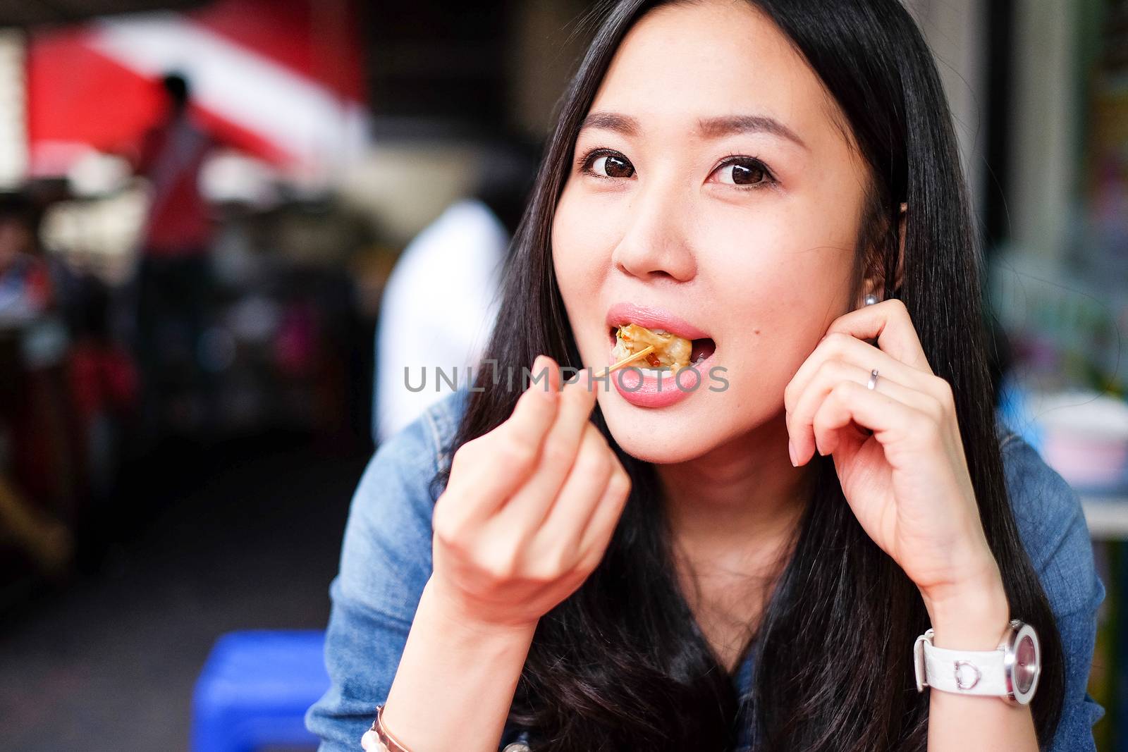 Woman eating Chinese Shanghainese steamed dumpling buns  by Surasak