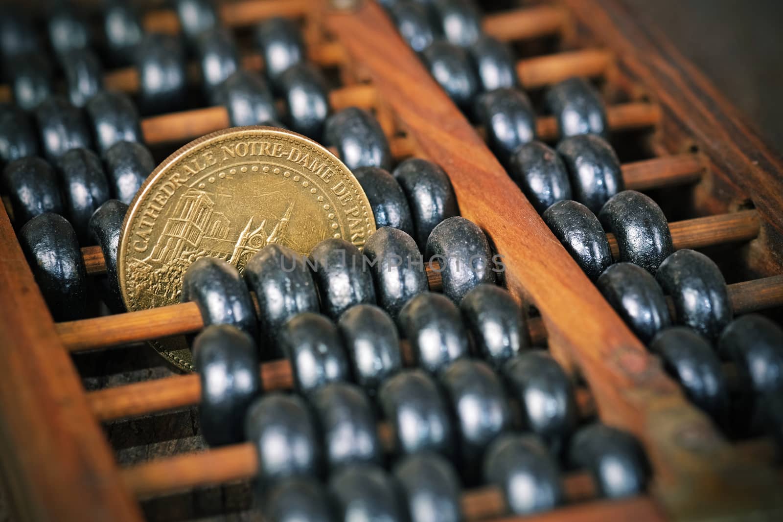 vintage wooden abacus with coin on wood background