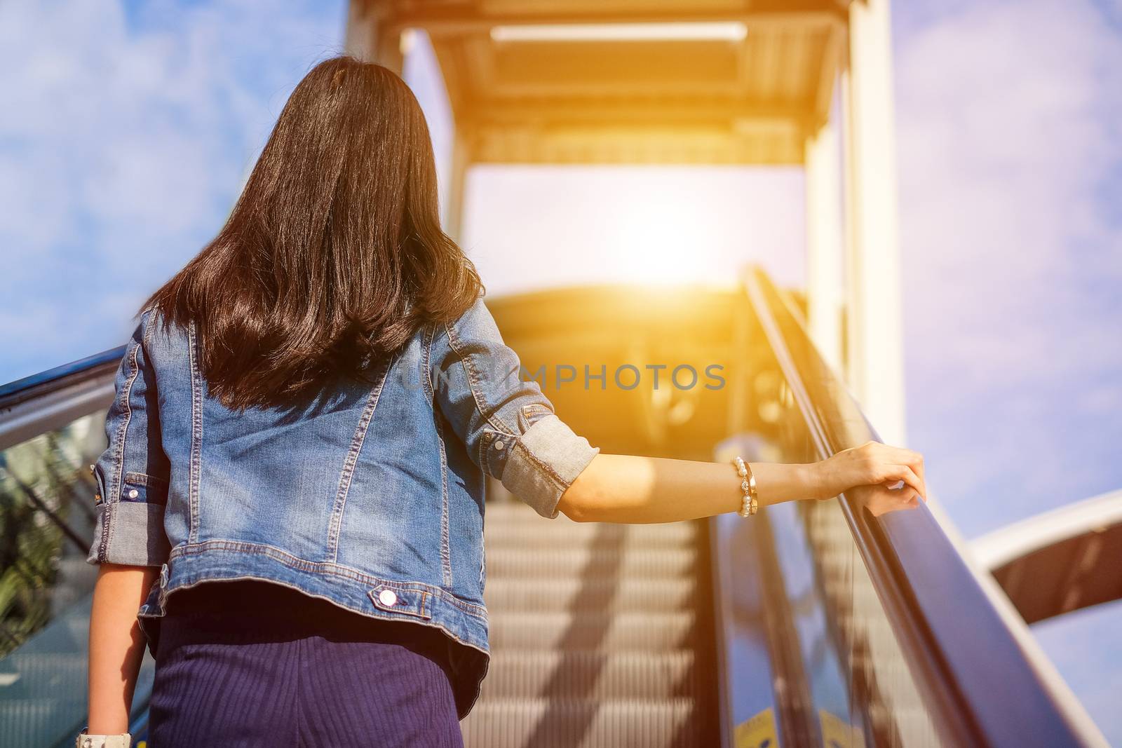 Young woman walking up stairs to reach her destination by Surasak