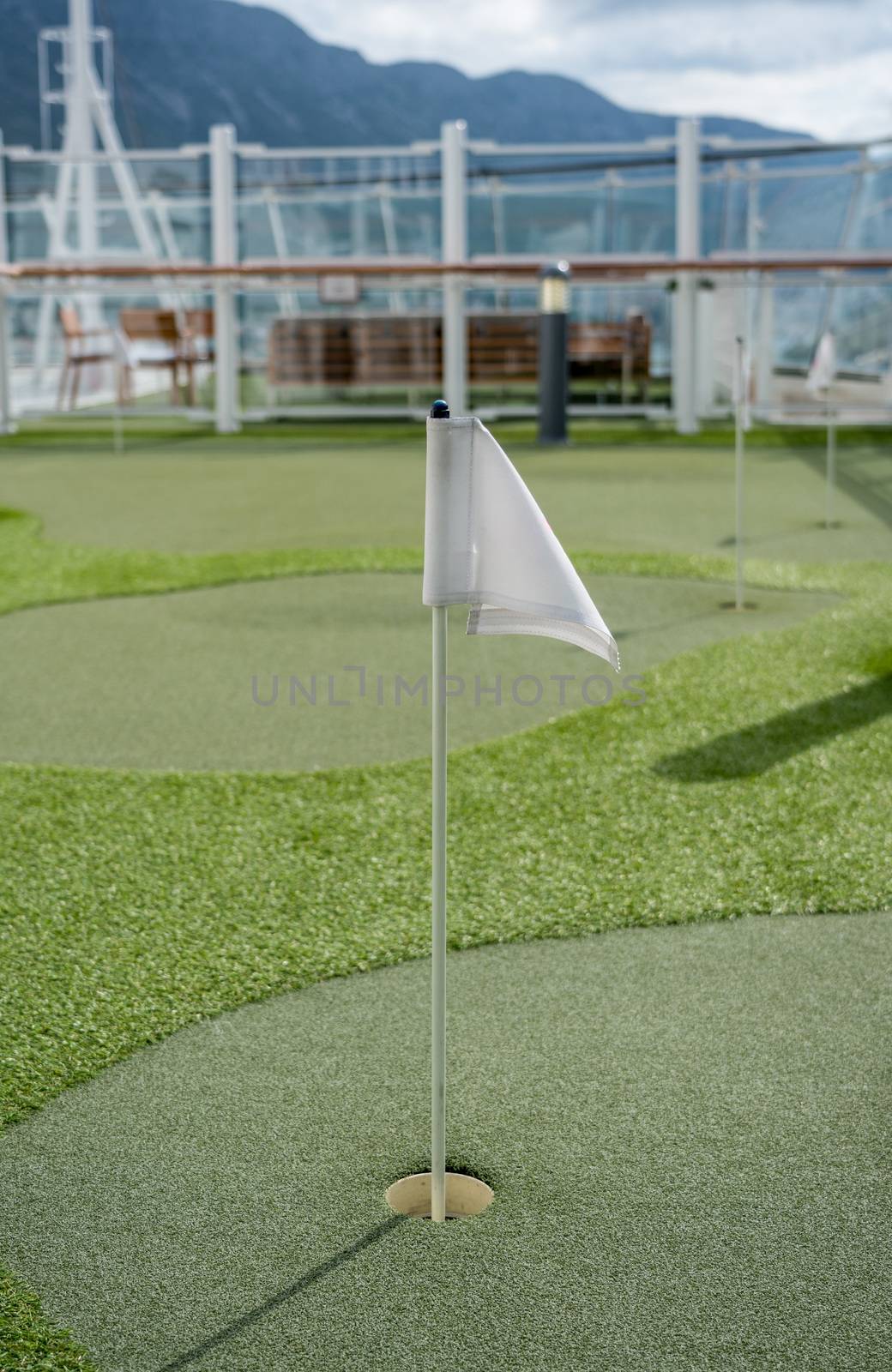 Small artificial putting green for golf practice on the deck of a cruise ship