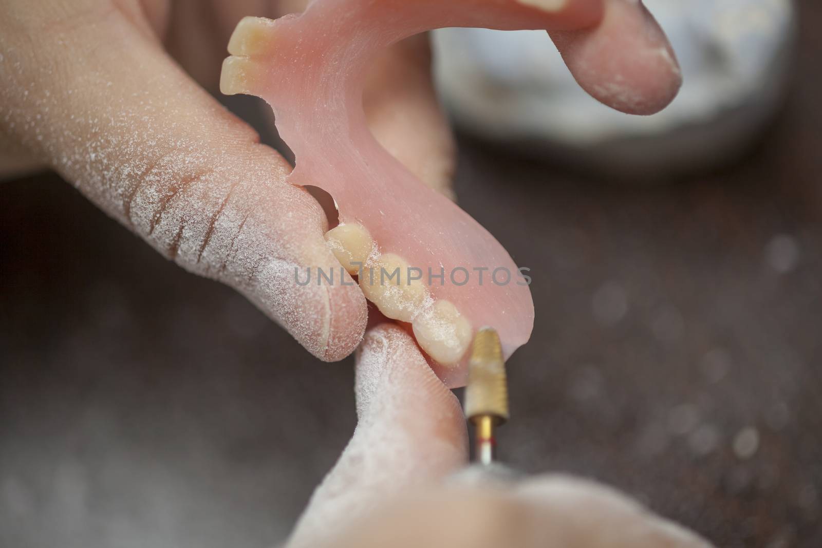 Dental technician make denture prothesis in dental laboratory, close up