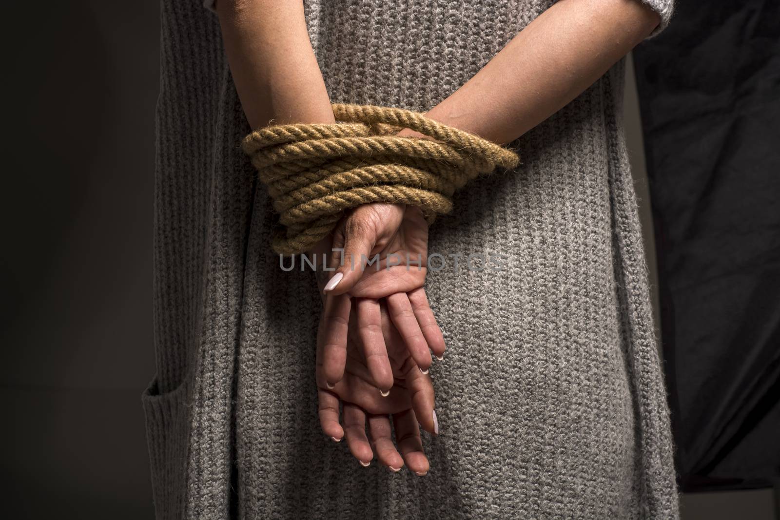 Womans hands on back tied with a rope, long nails