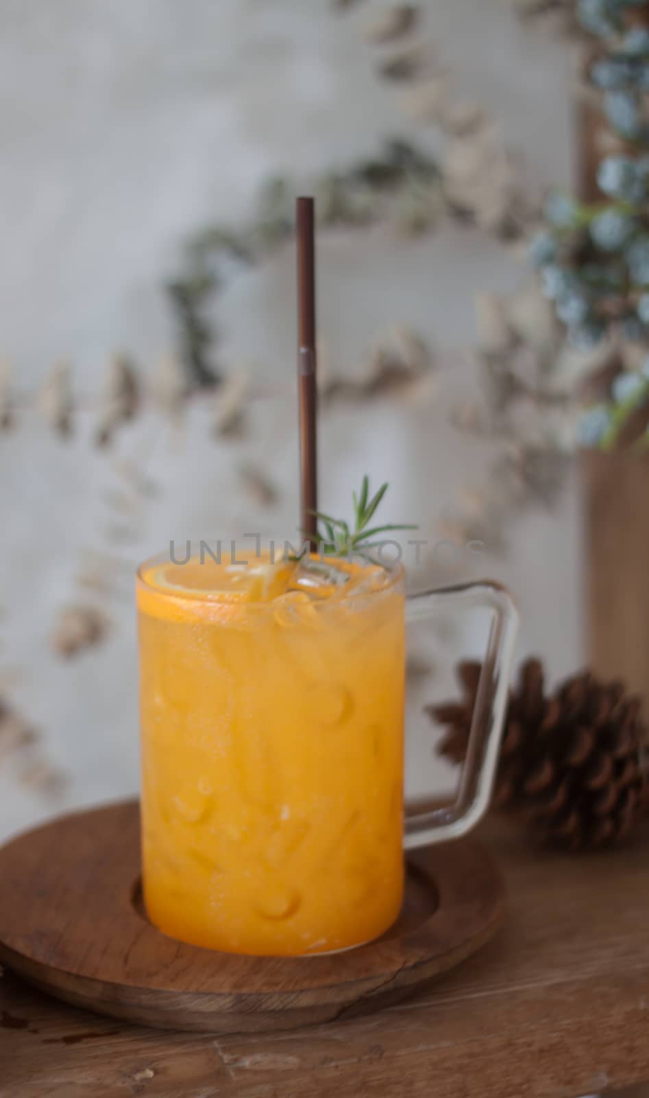 Glass of fresh orange juice with slice on wooden table