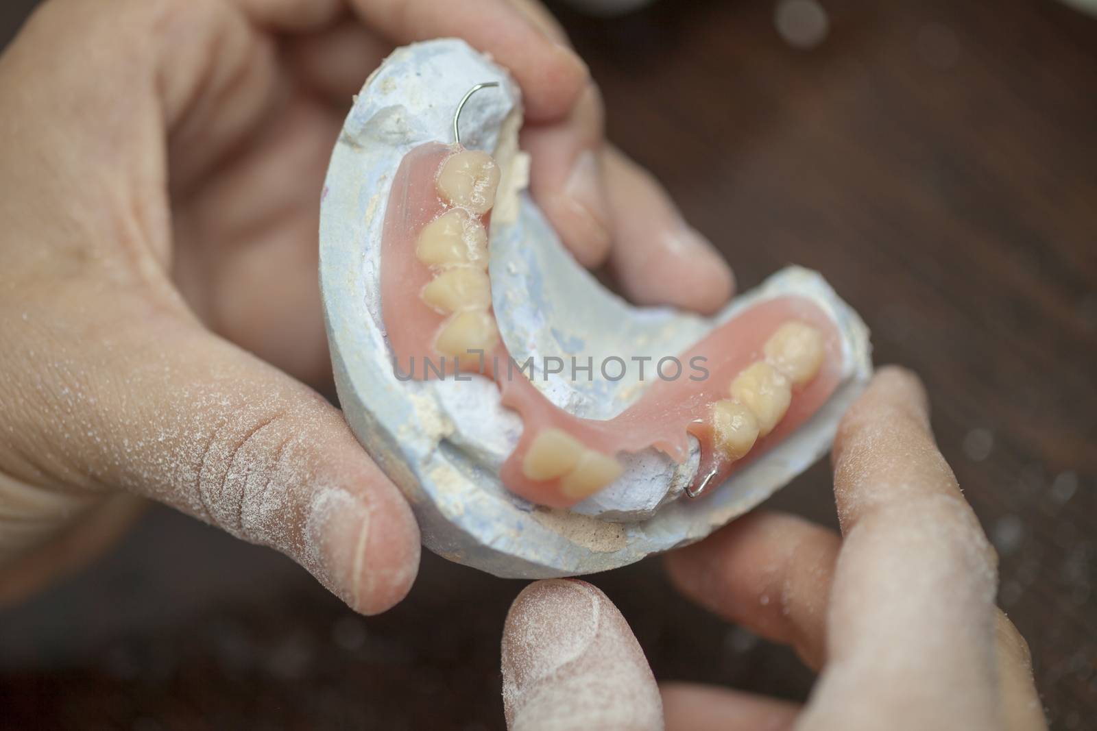 Dental technician make denture prothesis in dental laboratory, close up