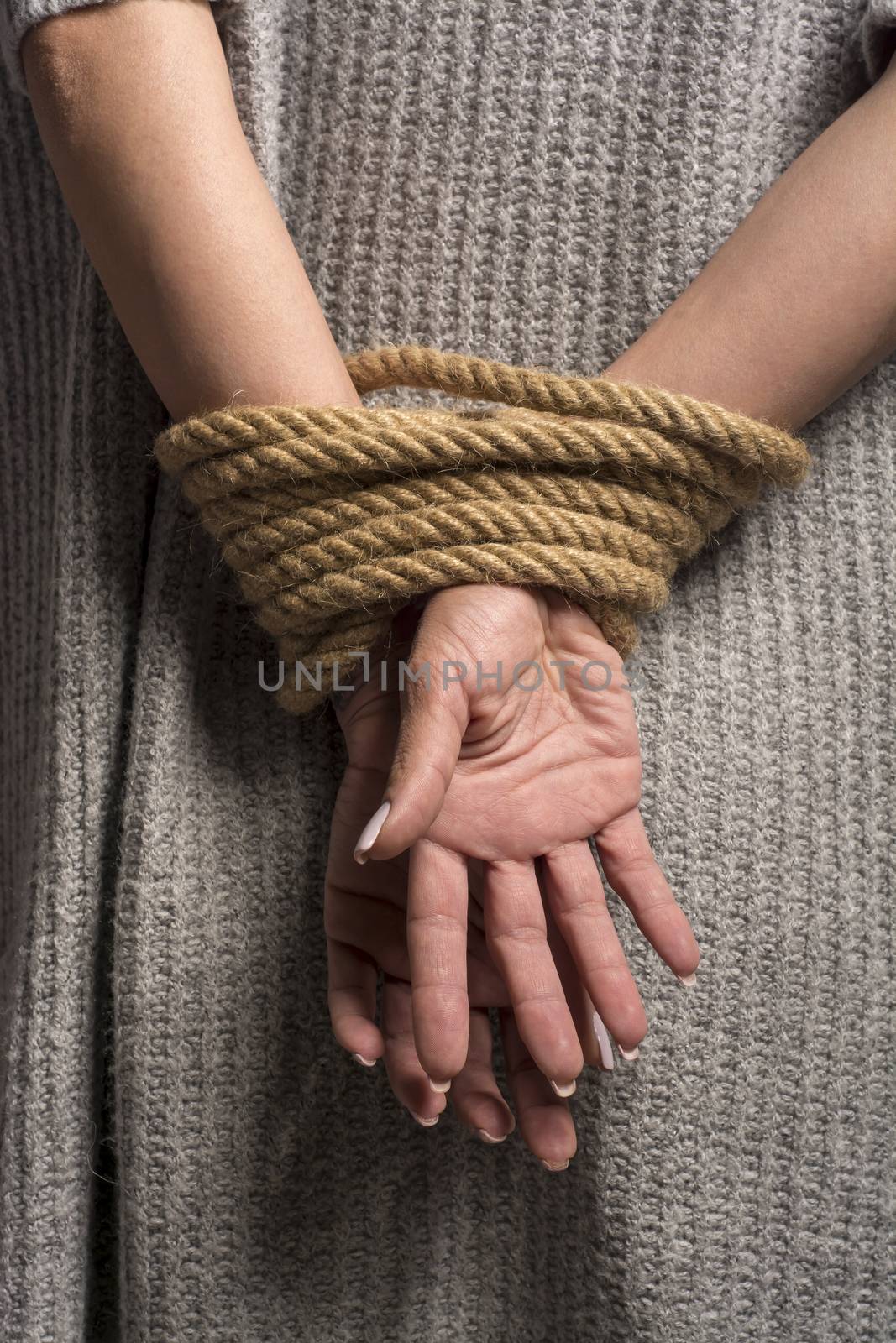 Womans hands on back tied with a rope, long nails