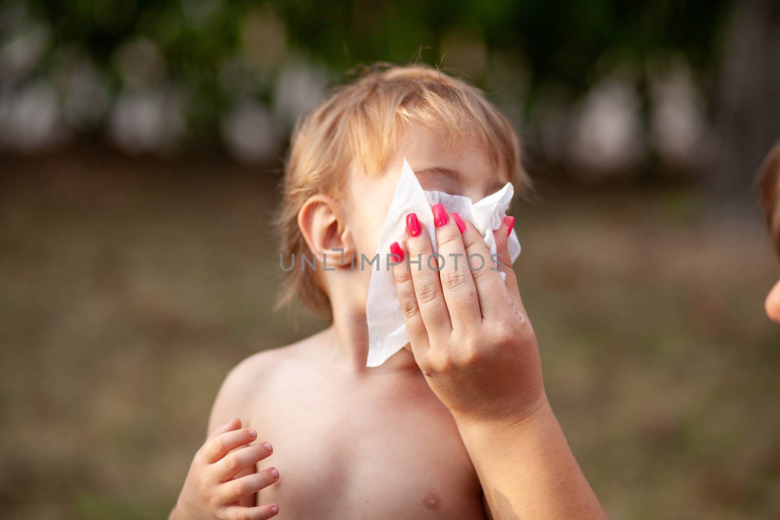 Hygiene - mom wiping the baby nose and face with wet wipes. Cleaning wipe, pure, clean, outdoor