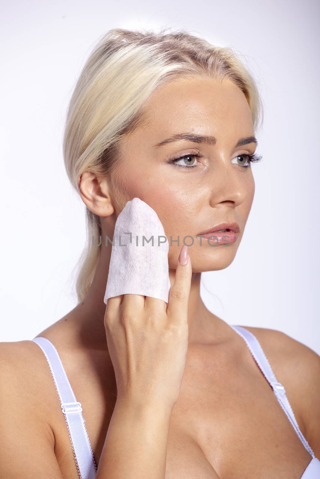 Young woman clean face with wet wipes by adamr