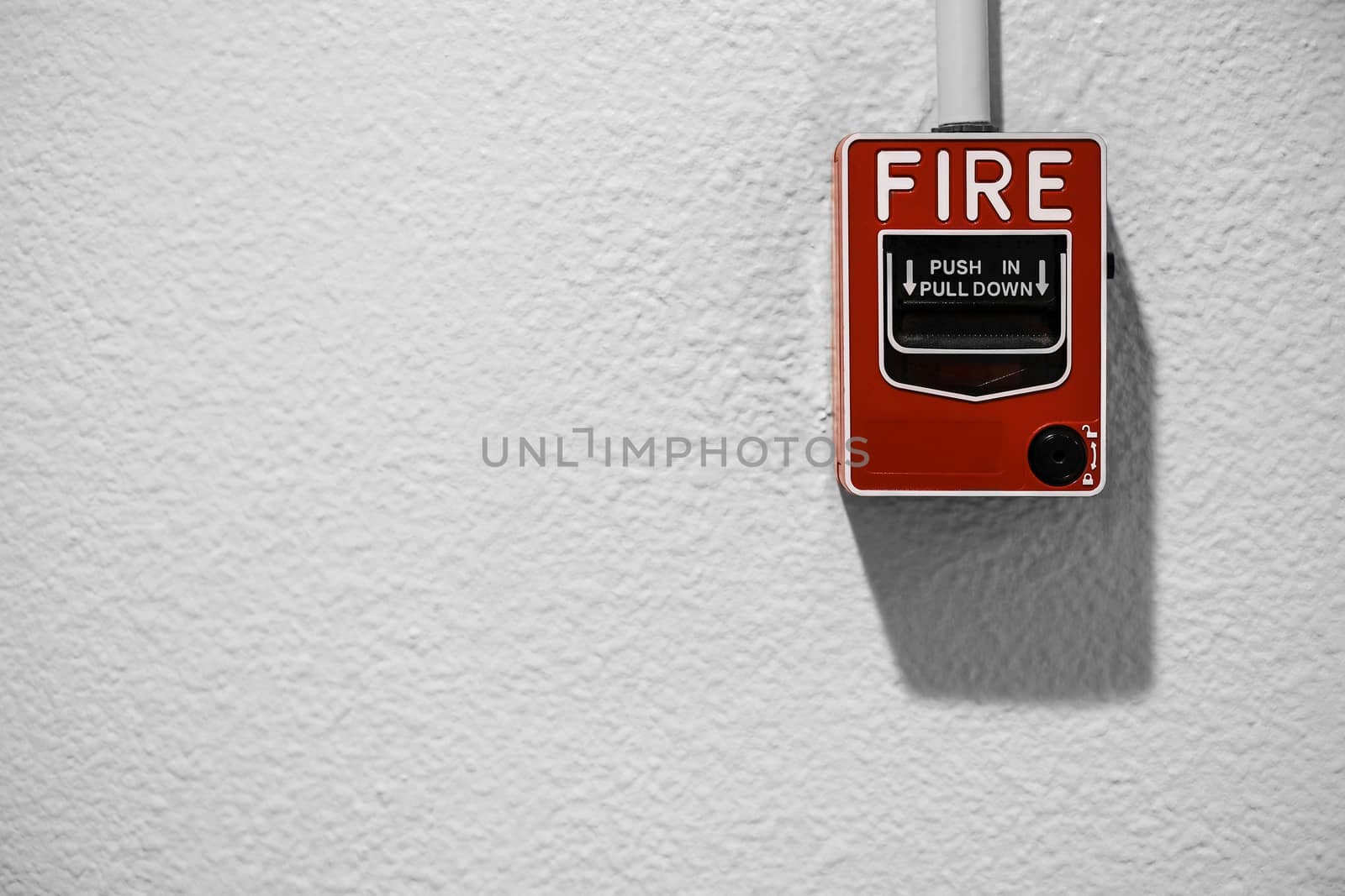 Fire alarm on white wall with copy space