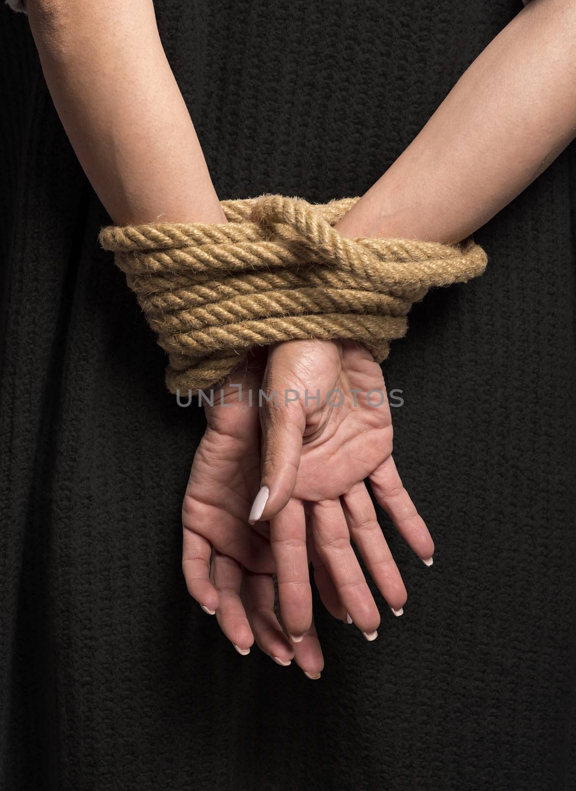 Womans hands on back tied with a rope, long nails