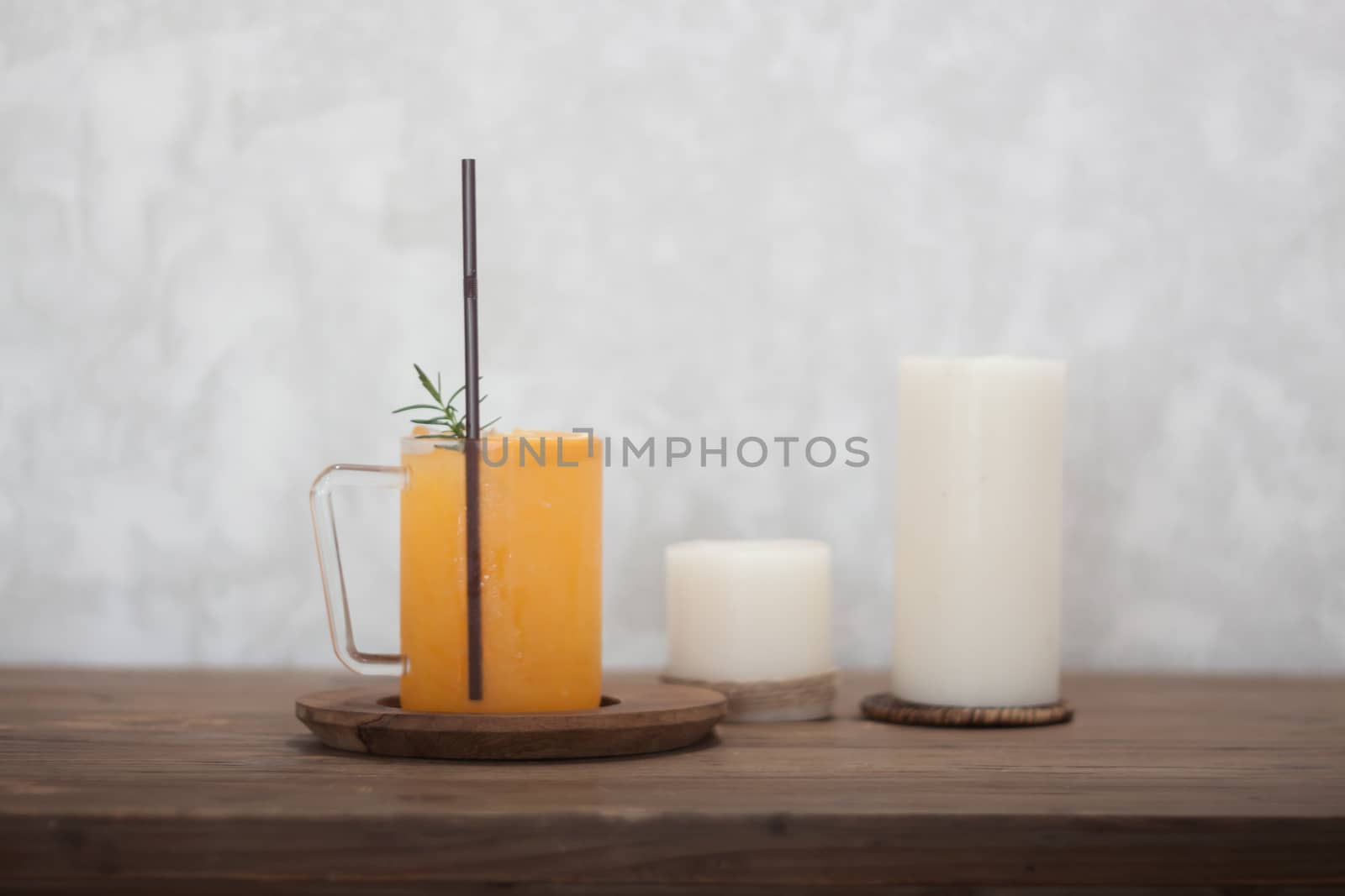 Glass of fresh orange juice with slice on wooden table