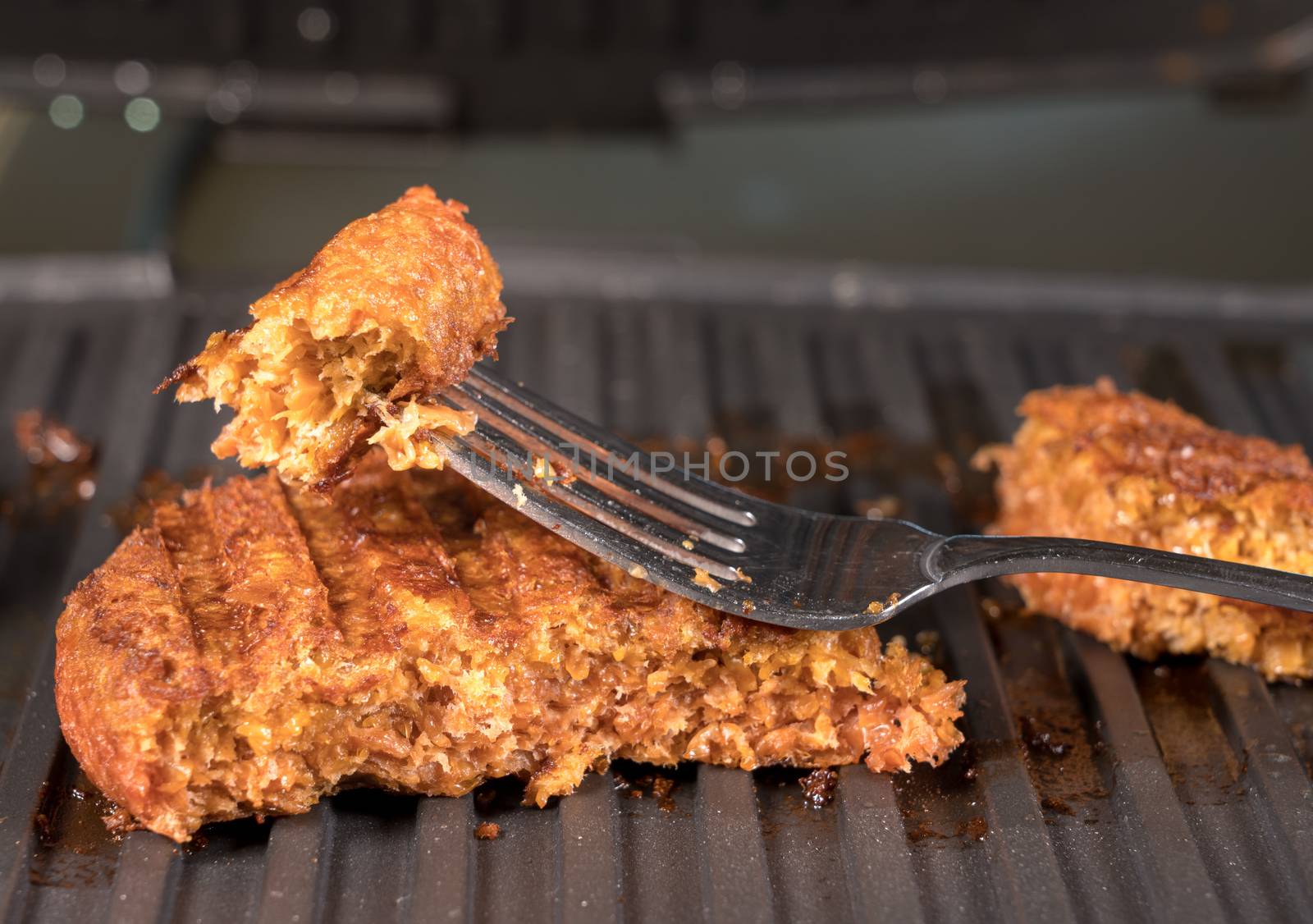 Close shot of the meat like plant-based patties for vegetarian beef burgers being grilled on hot griddle