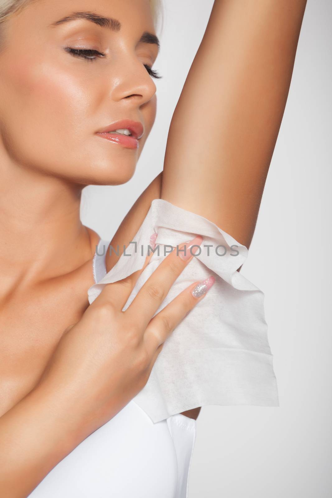 Higiene - young woman wiping the armpit with wet wipes, perspiration, sweat