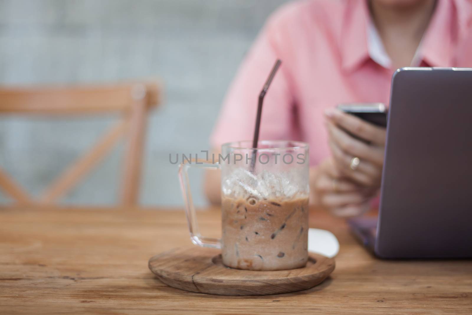 Woman using smart phone in coffee shop by punsayaporn