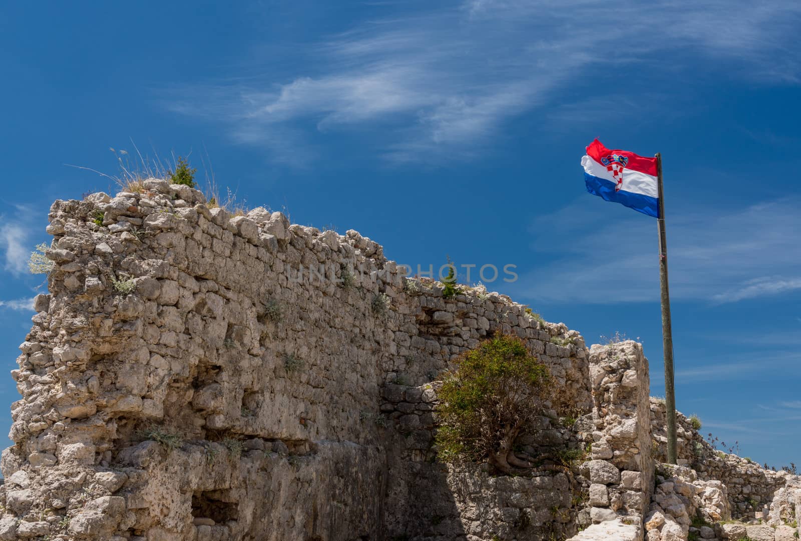 Croatian flag flies above ruins of old Venetian fort above the coastal town of Novigrad in Croatia