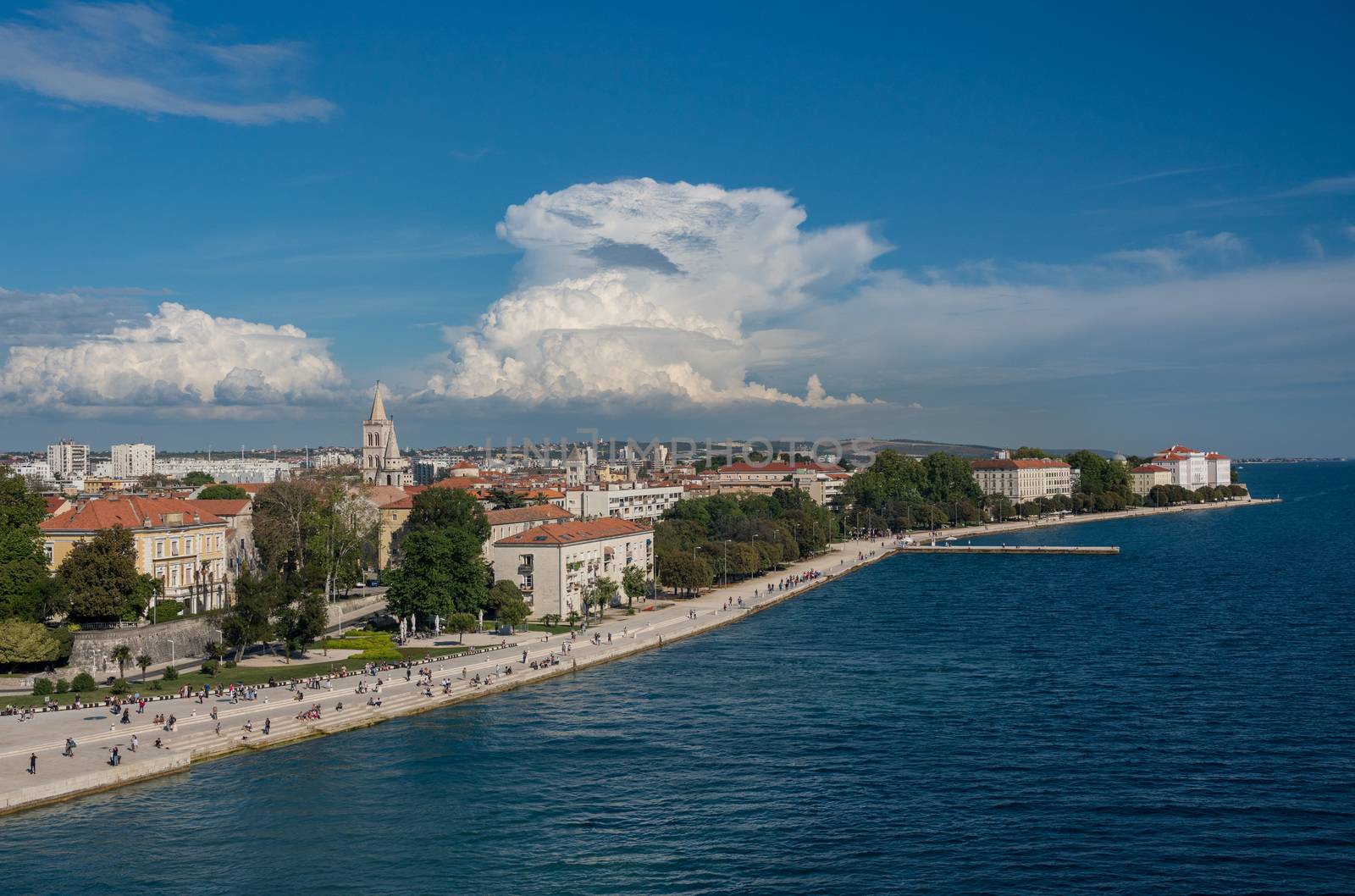 Tourists on the steps of Sea Organ along the promenande by the port of Zadar in Croatia