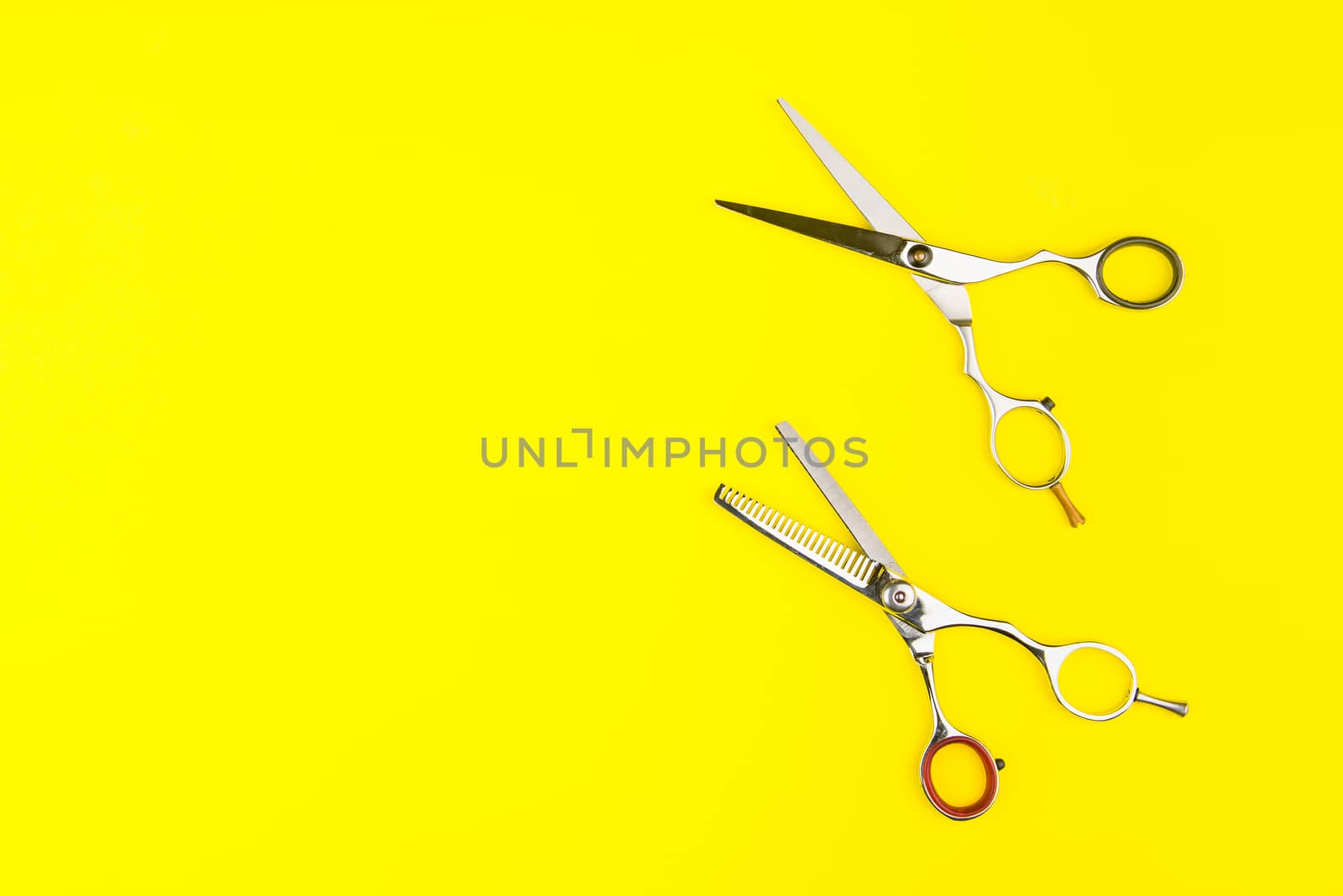 Stylish Professional Barber Scissors on yellow background. Hairdresser salon concept, Hairdressing Set. Haircut accessories. Copy space image, flat lay