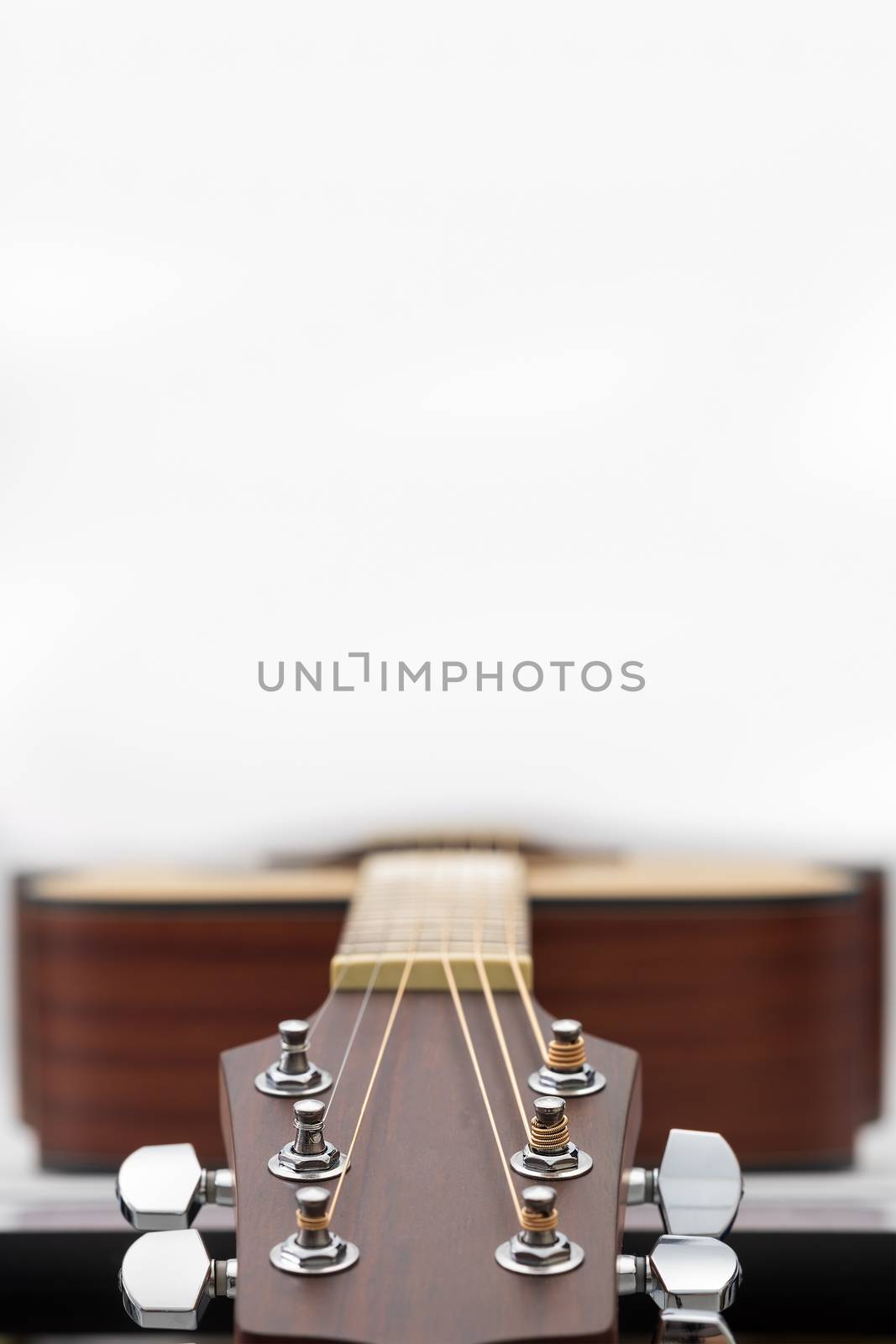 Close up of an acoustic guitar headstock on white background with copy space.
