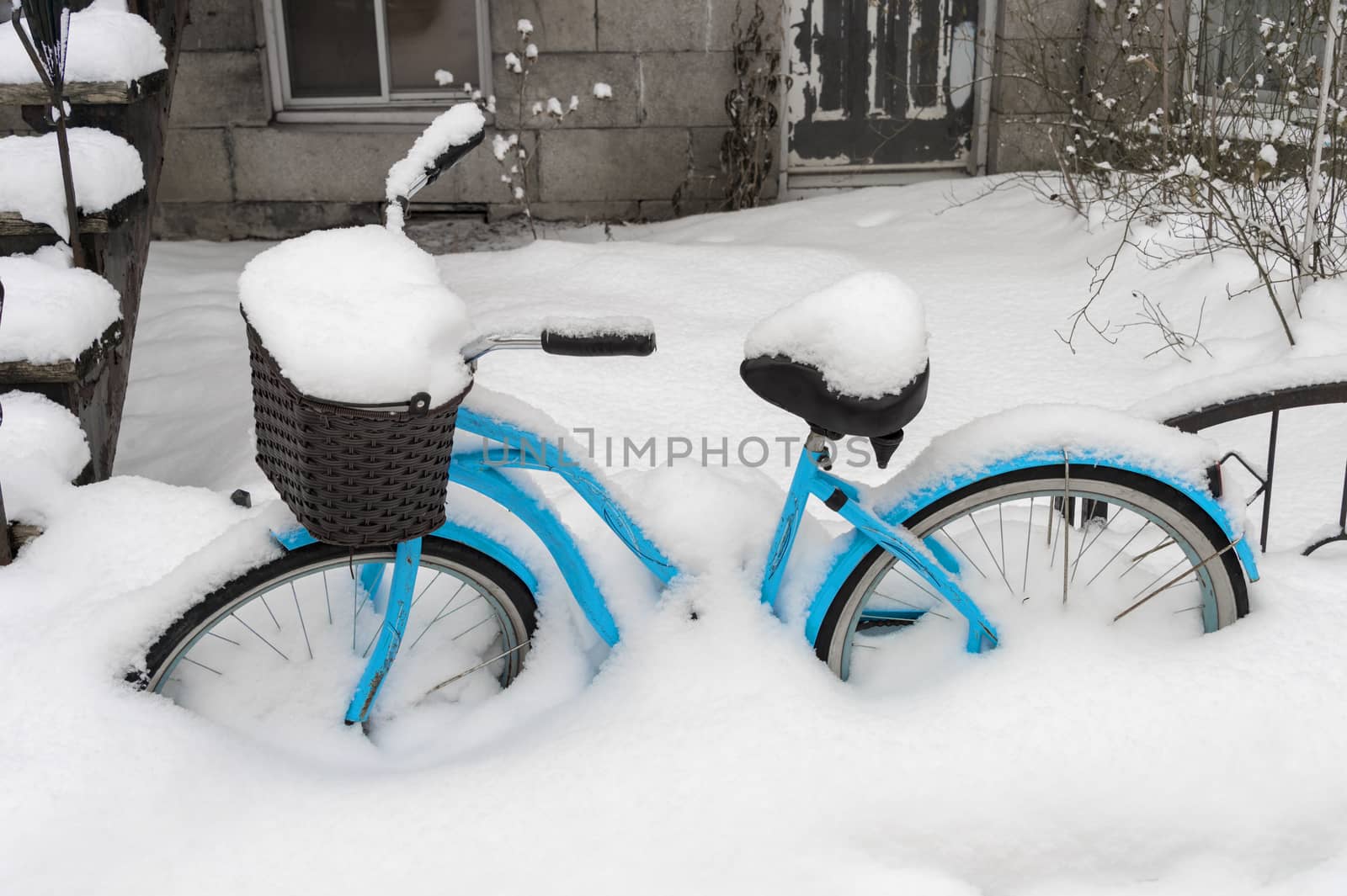 Blue bike covered in snow after snow storm in Montreal by mbruxelle