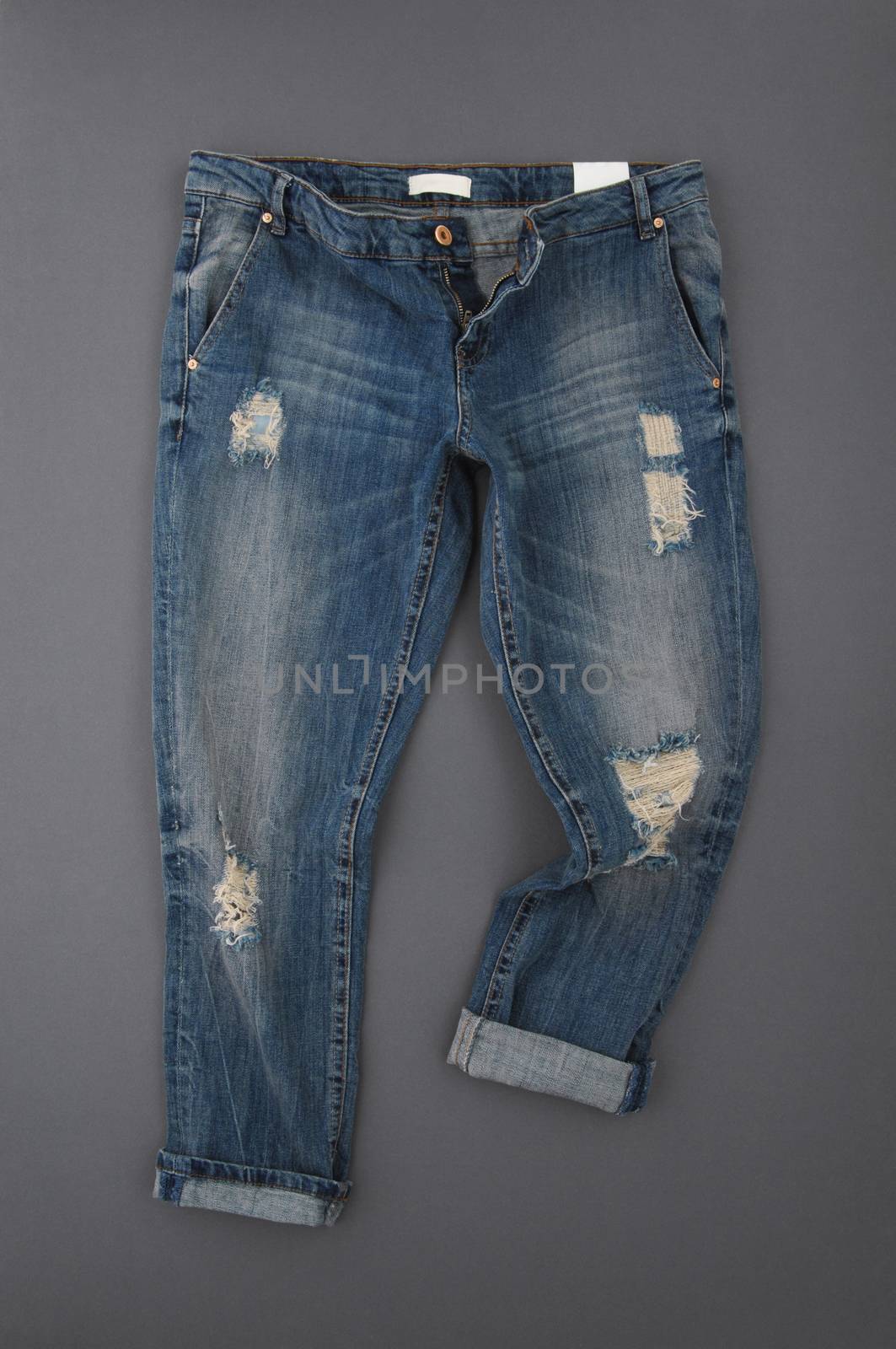 fashionable denim pants on grey background, top view