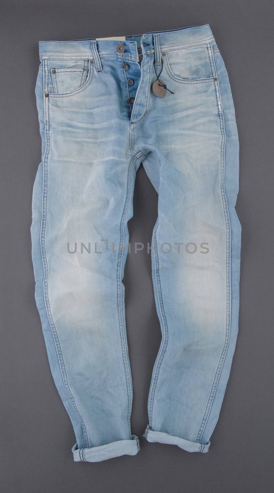 fashionable denim pants on grey background, top view