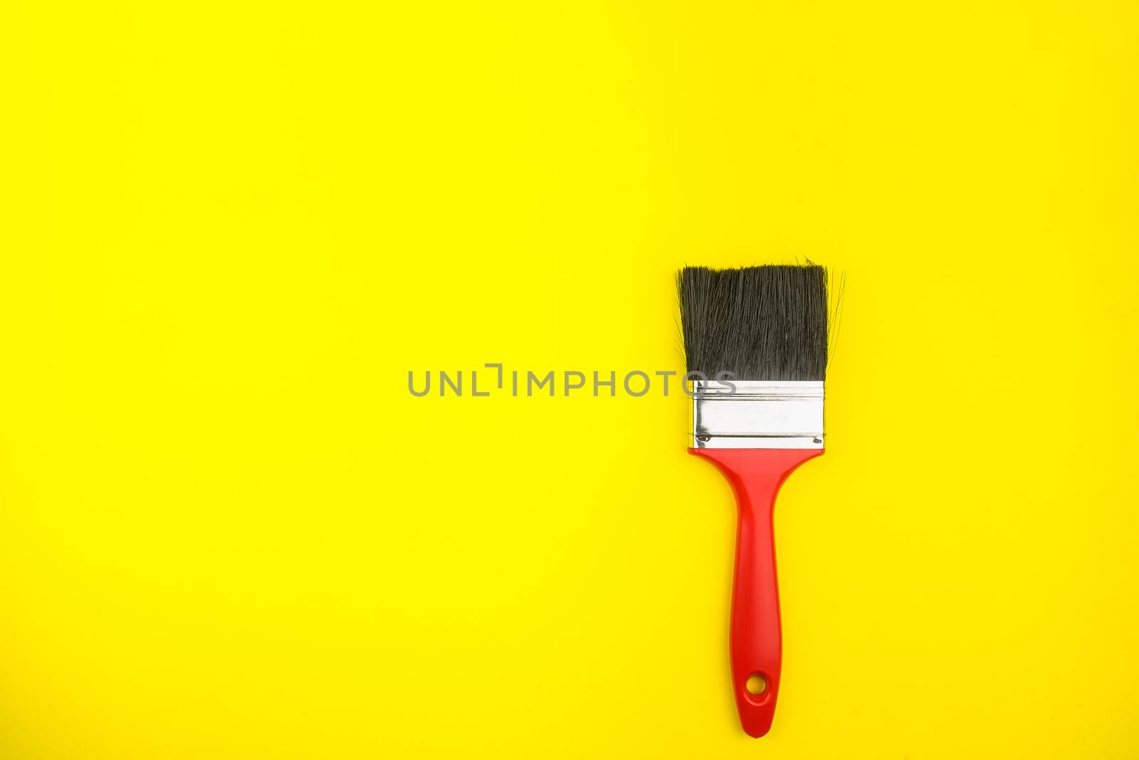 Top view of paint brushes on yellow background with copy space, minimalistic style