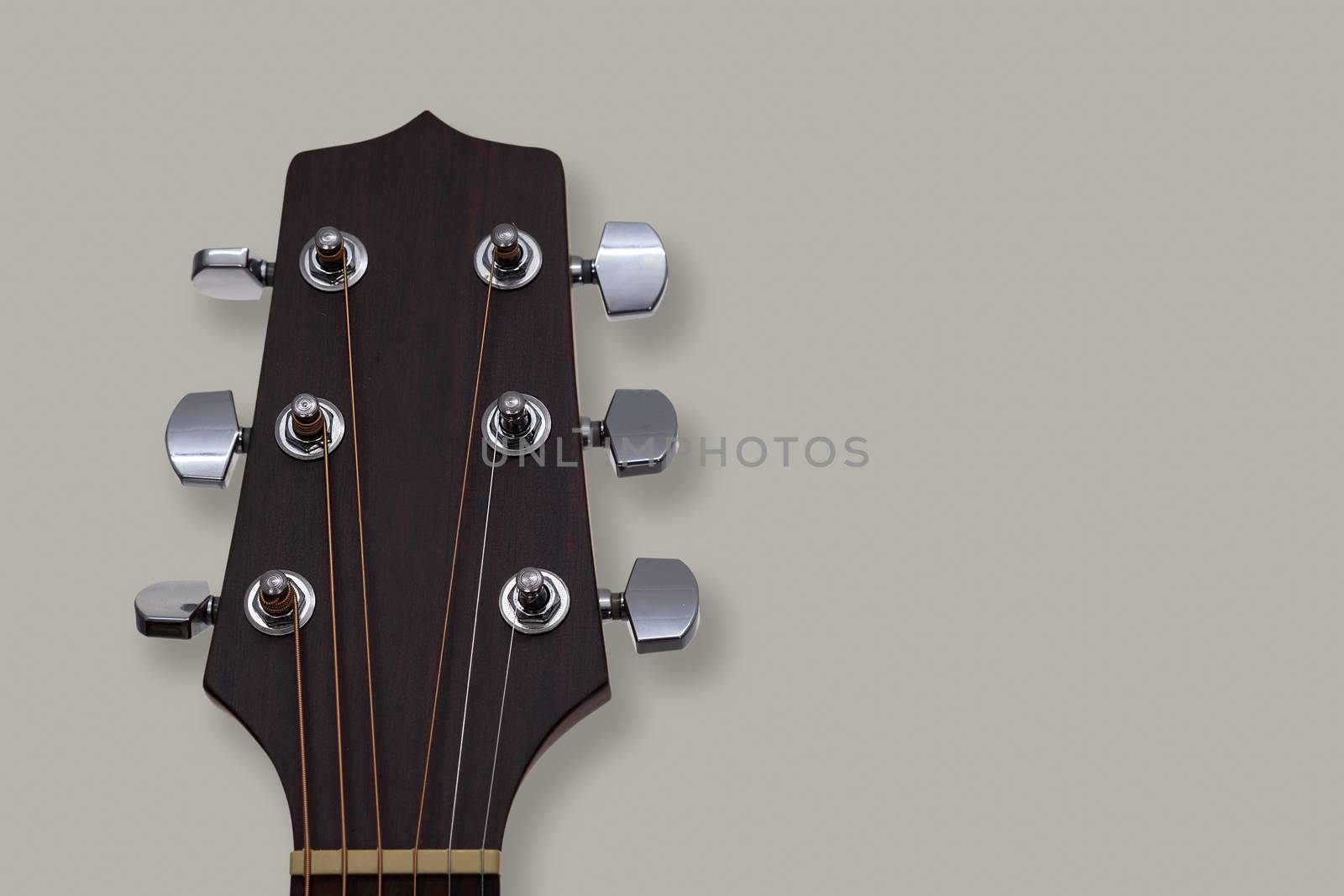 An acoustic guitar headstock on grey background. by feelartfeelant