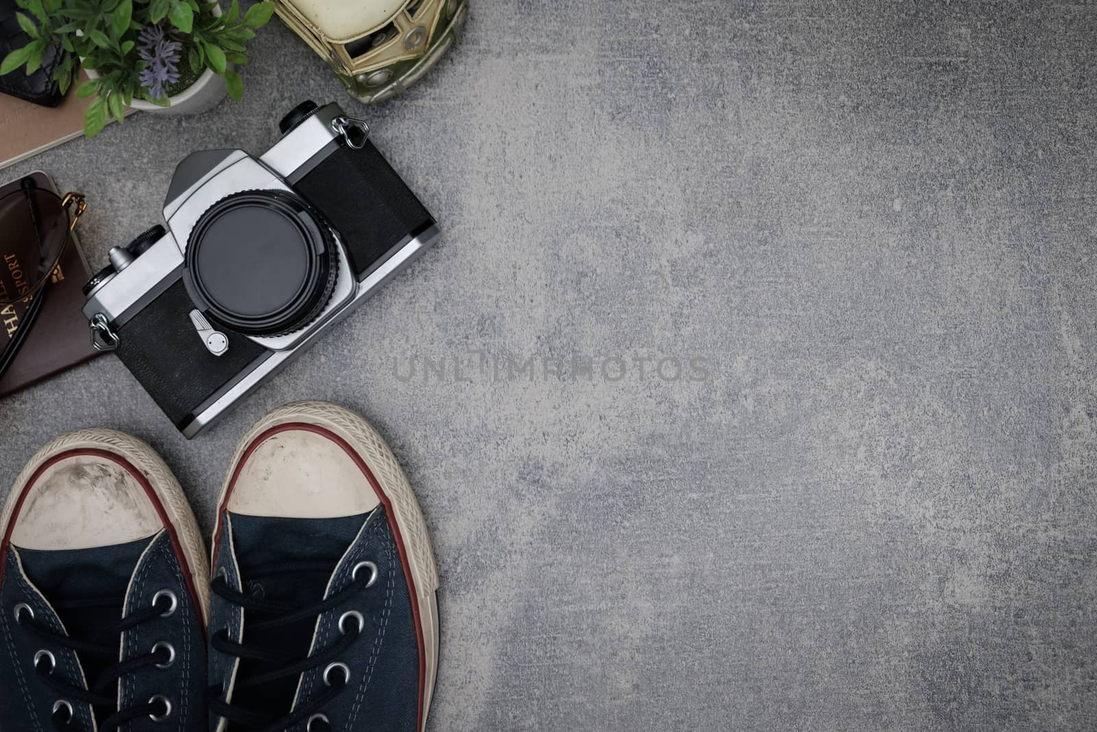 Top view travel concept with retro camera films,other items on grey cement background with copy space.