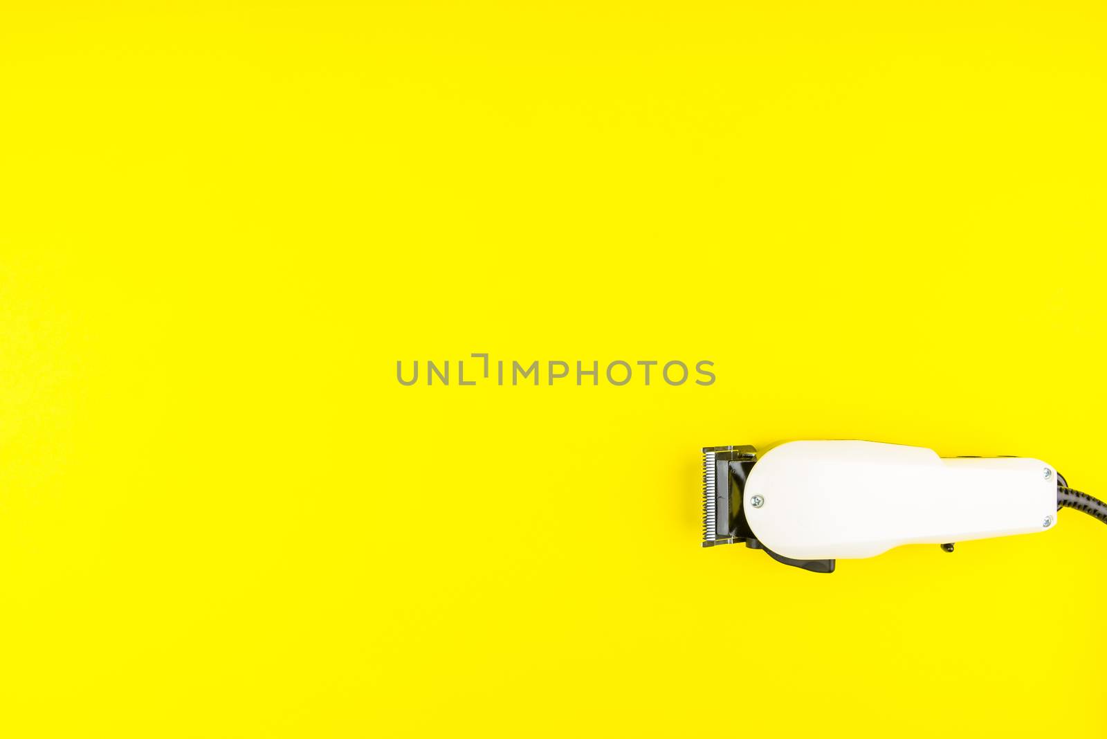White electric clippers barber on yellow background. Hairdresser by Bubbers