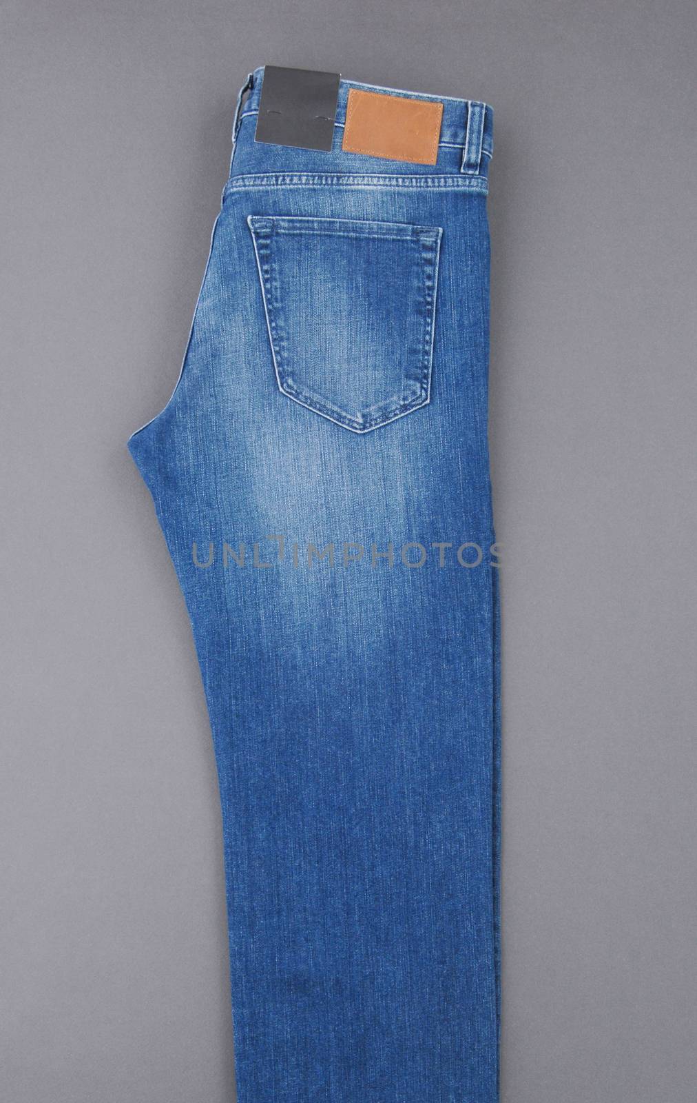 fashionable denim pants on grey background, top view