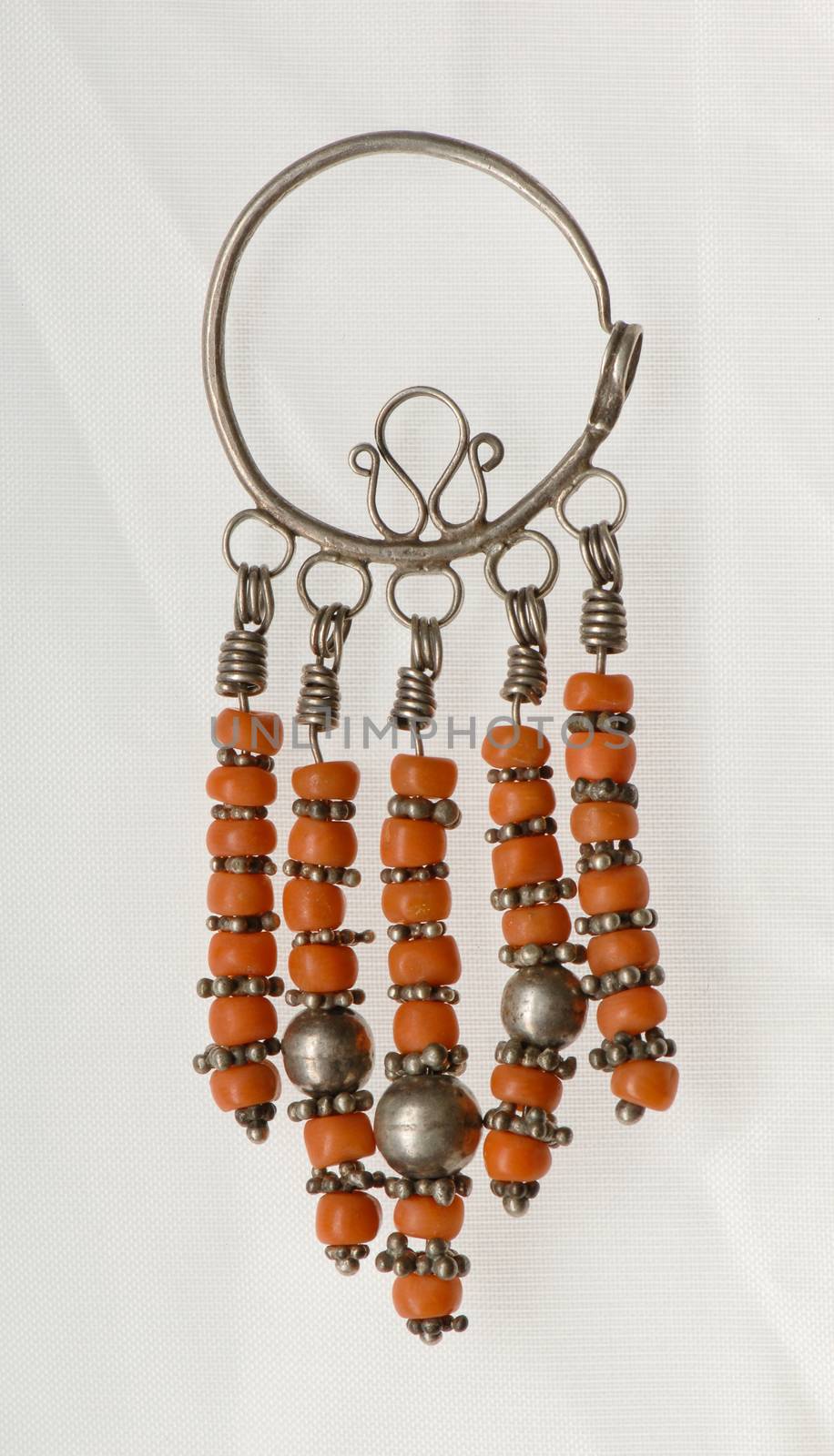 ancient Oriental earrings with precious stones on a textured white background