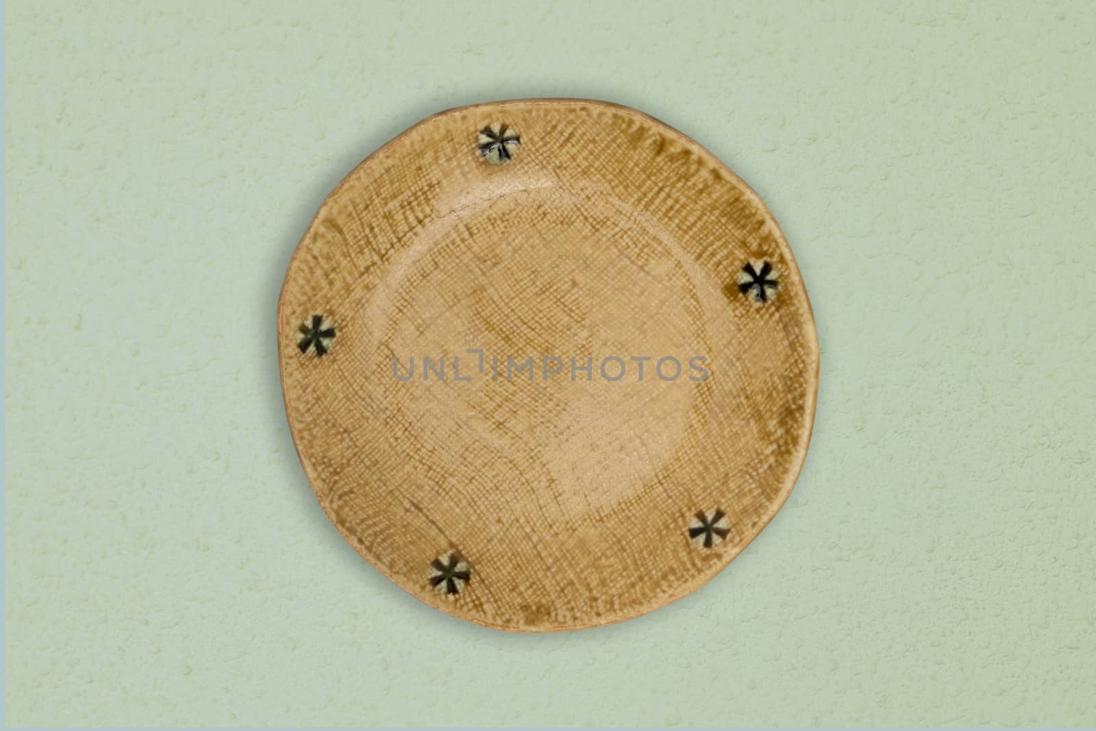 Top view-Empty yellow ceramic round dish plate isolated on green background.