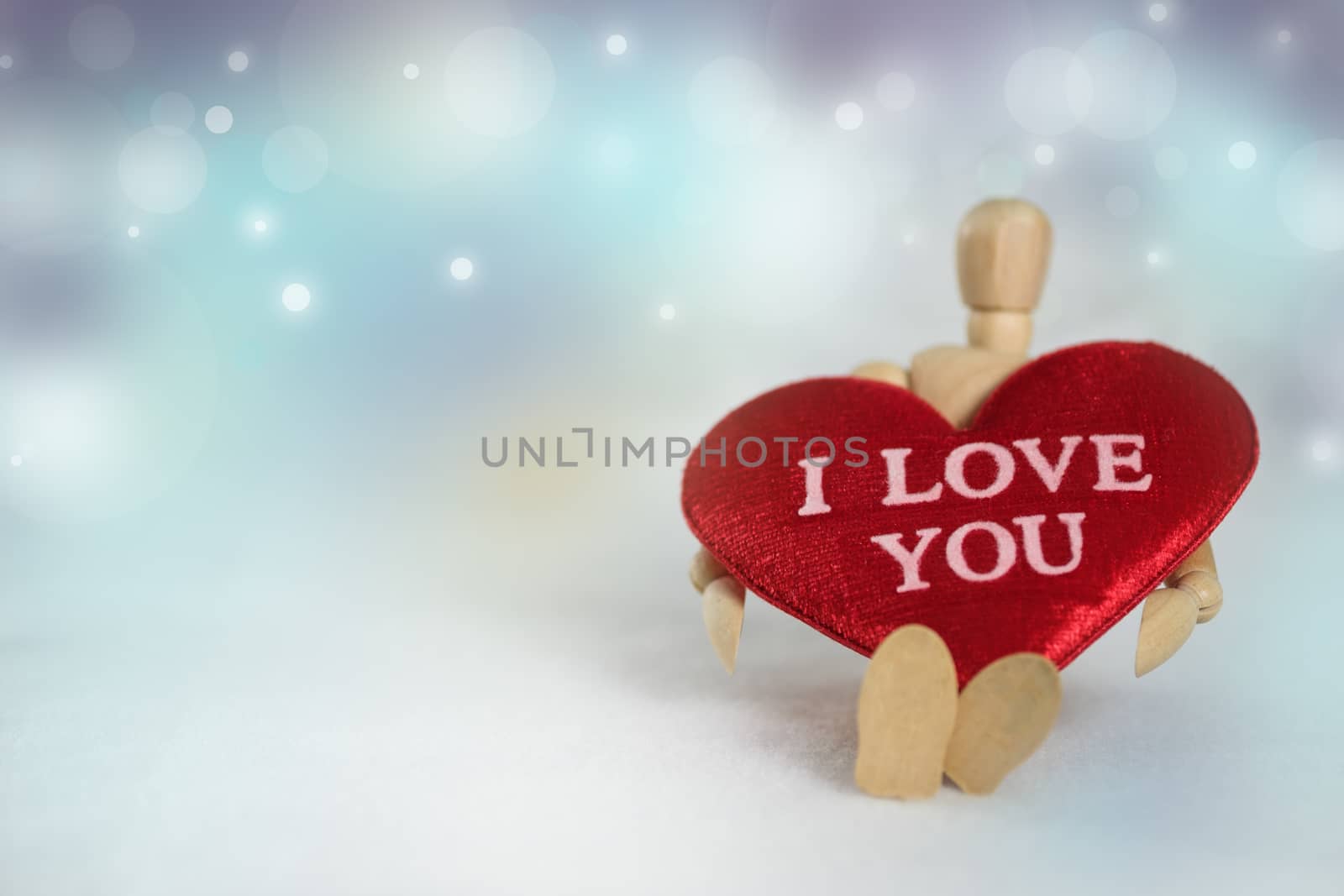 Wooden dummy and heart shape on abstract bokeh background in love concept for valentines day with romantic moment.