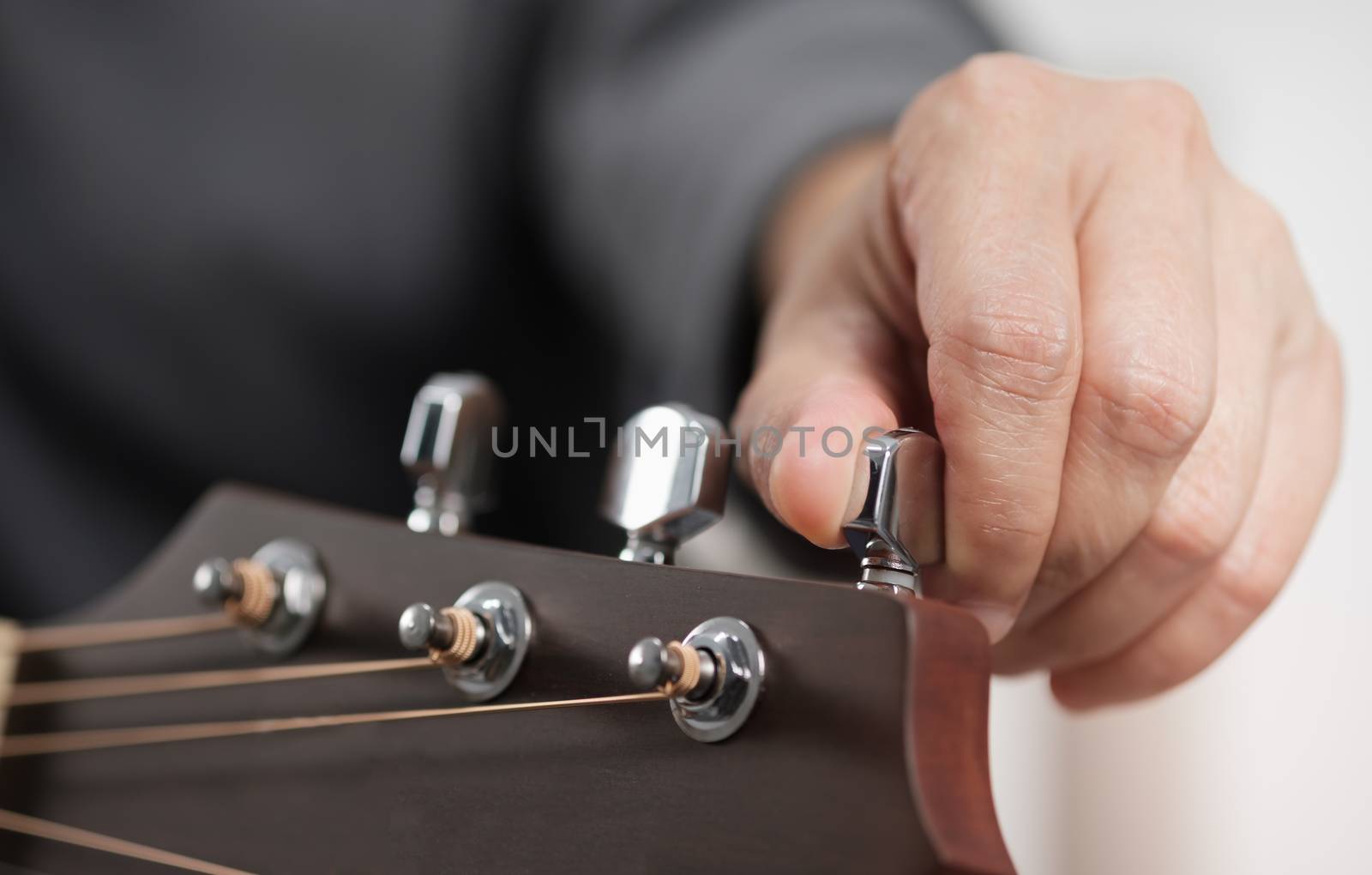 Close up woman's hands adjusting acoustic guitar.