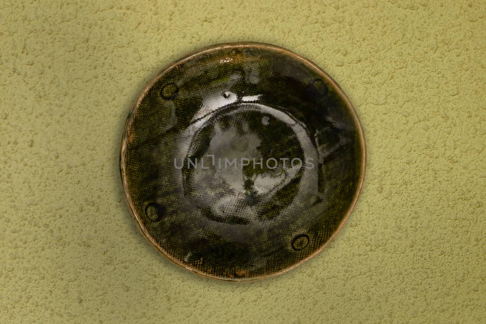 Top view-Empty green ceramic round dish plate isolated on yellow background.