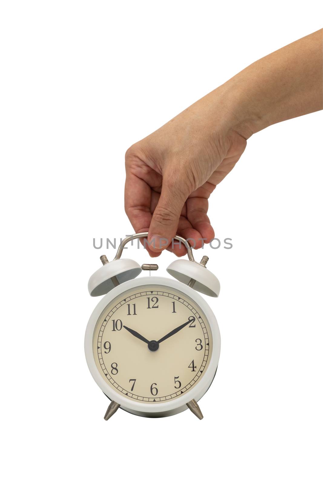 Hand holding white vintage alarm clock isolated on white  background.