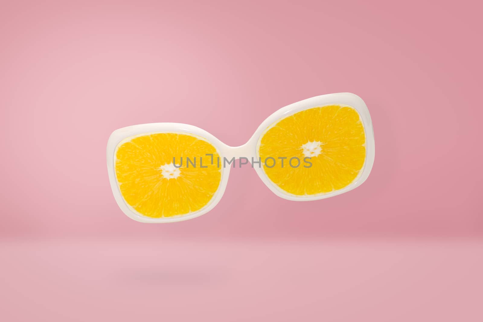 Beach sunglasses  with orange lens on pink pastel, summer concept and minimal style.