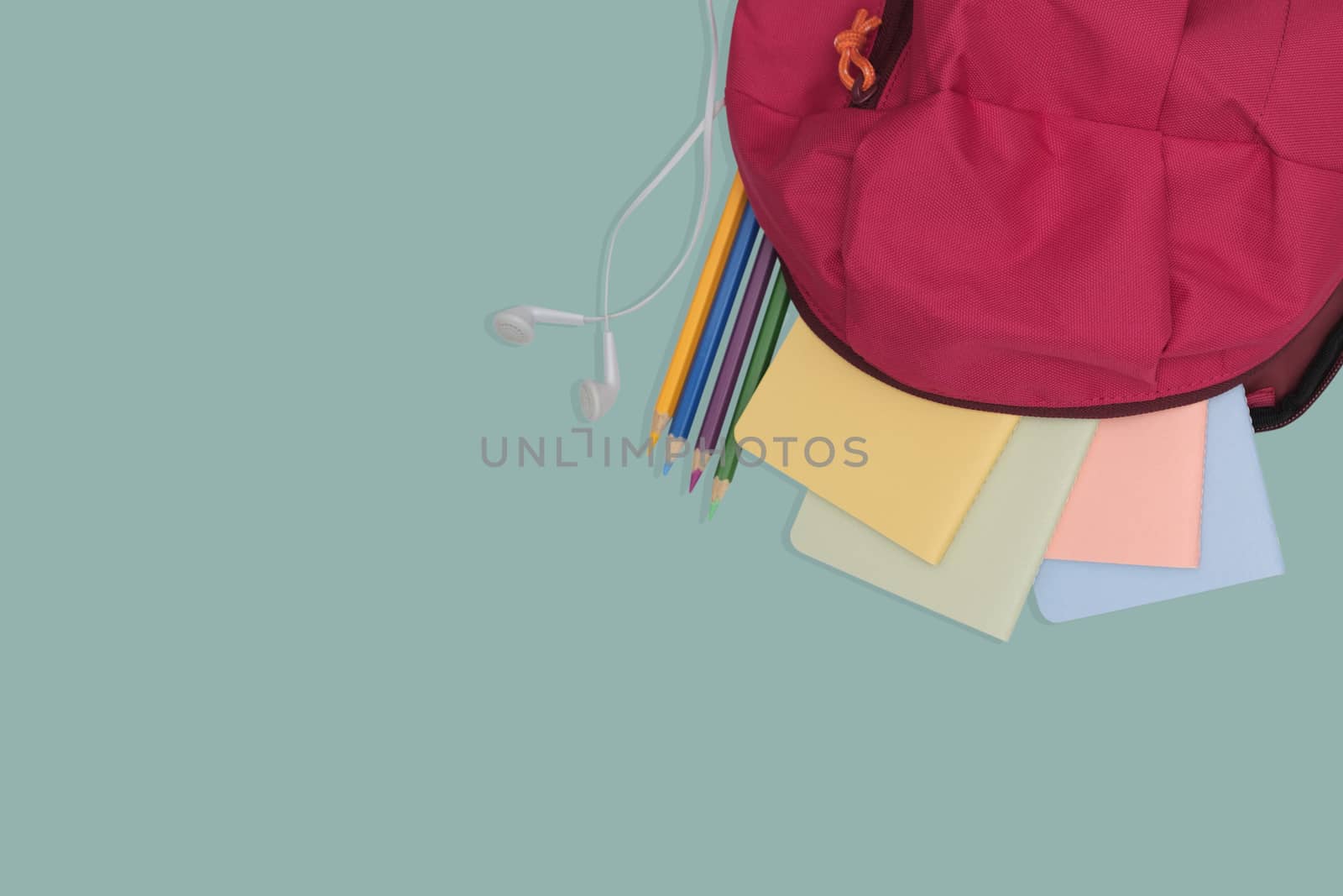 school bag with book and color pencil isolated on green background, back to school concept.
