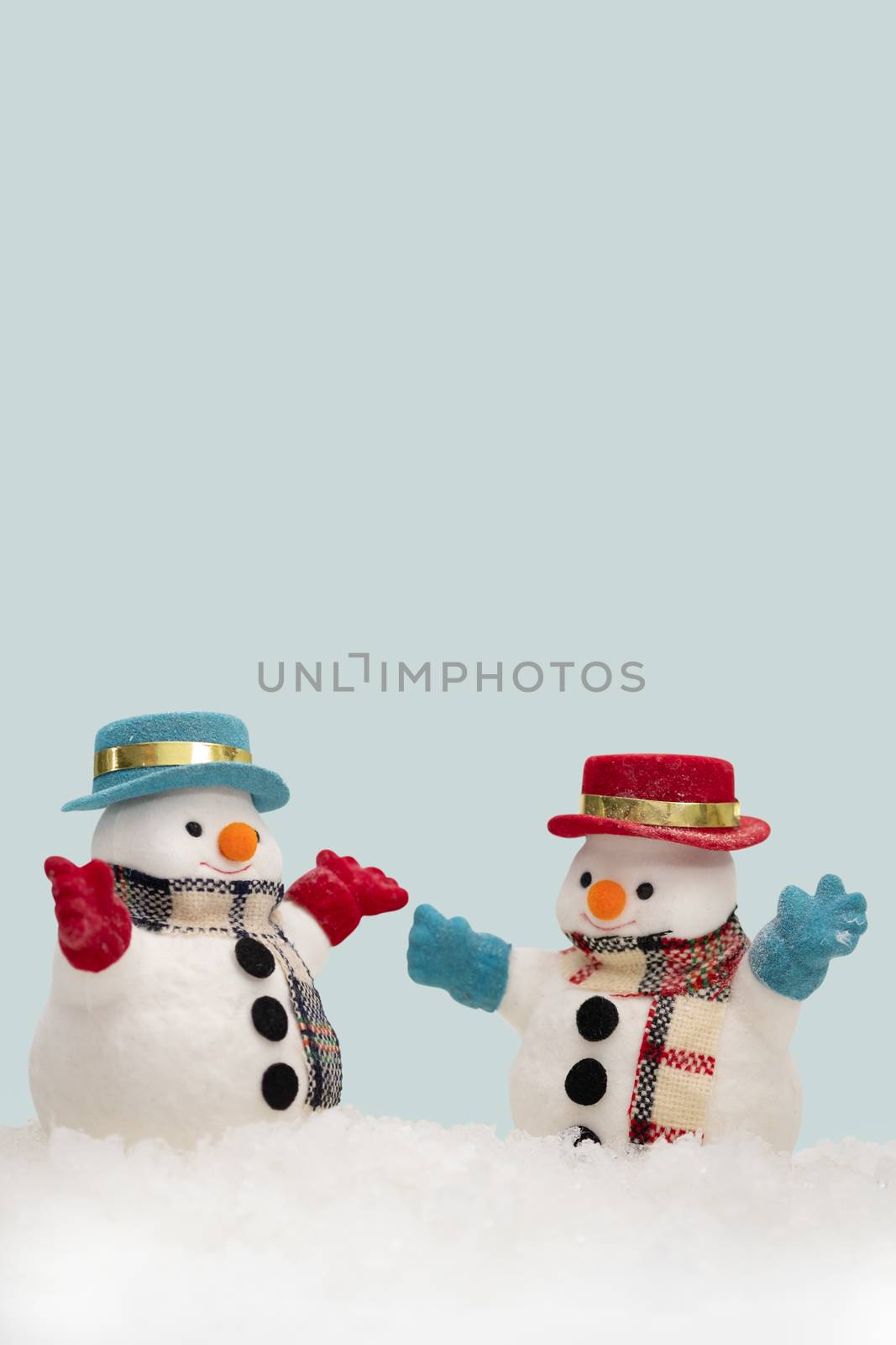 Two snowman on blue background with copy space for season greeting Merry Christmas, AF point selection,