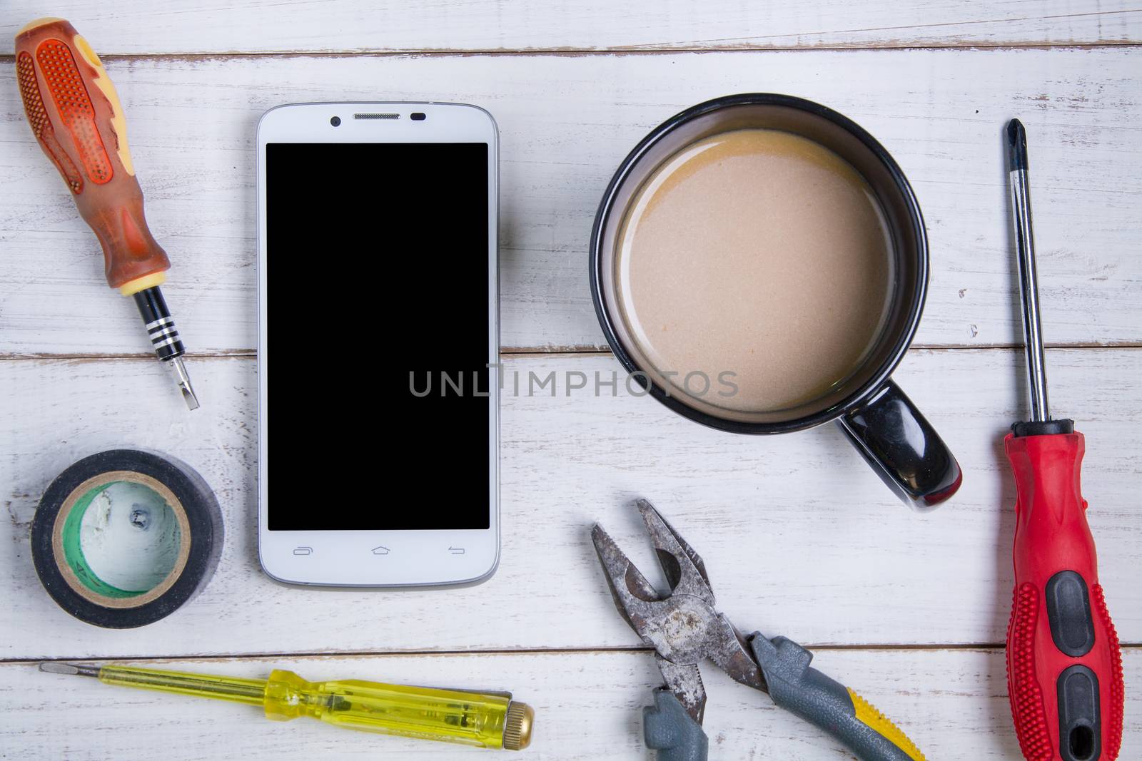 smartphone, coffee cup and equipment repair on the white wooden  by Bubbers