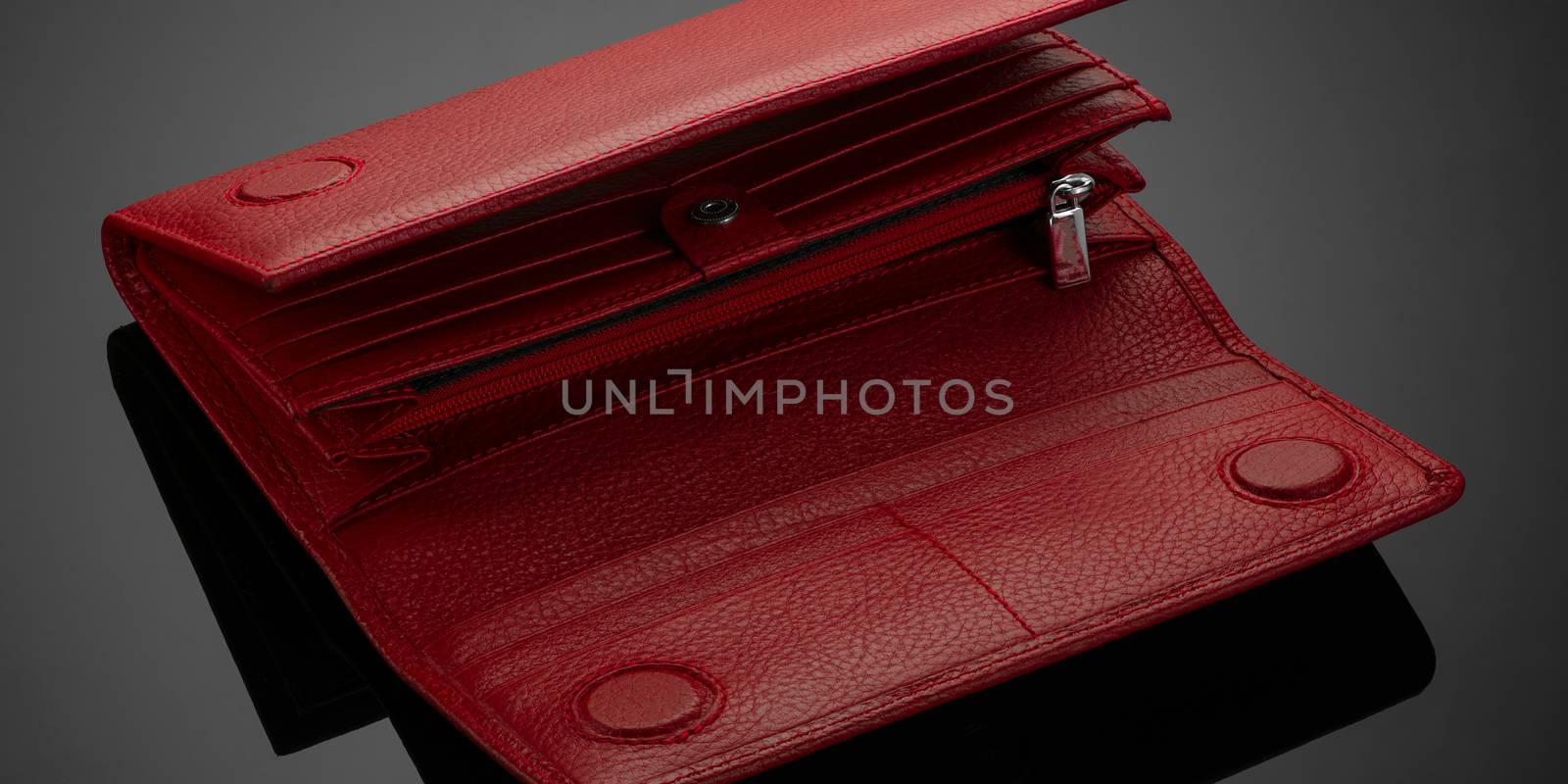 Fashionable red leather women's wallet on a dark background