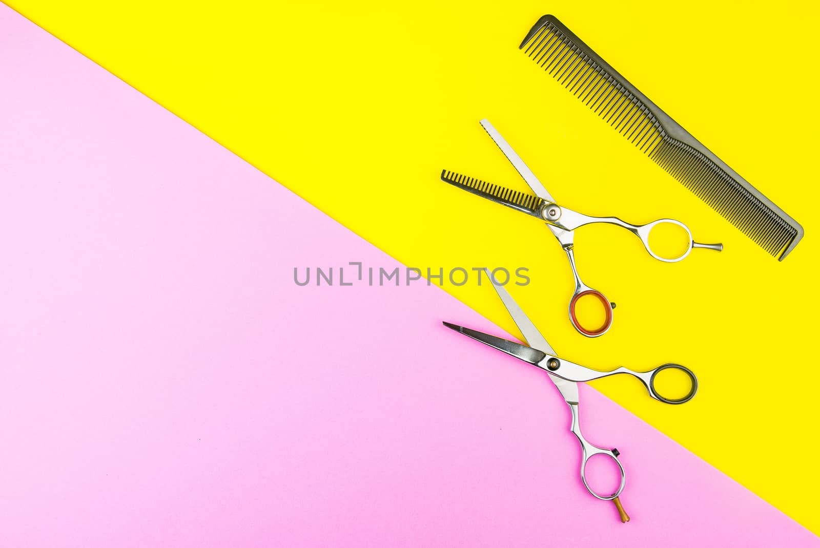 Stylish Professional Barber Scissors and comb on yellow and pink background. Hairdresser salon concept, Hairdressing Set. Haircut accessories. Copy space image, flat lay