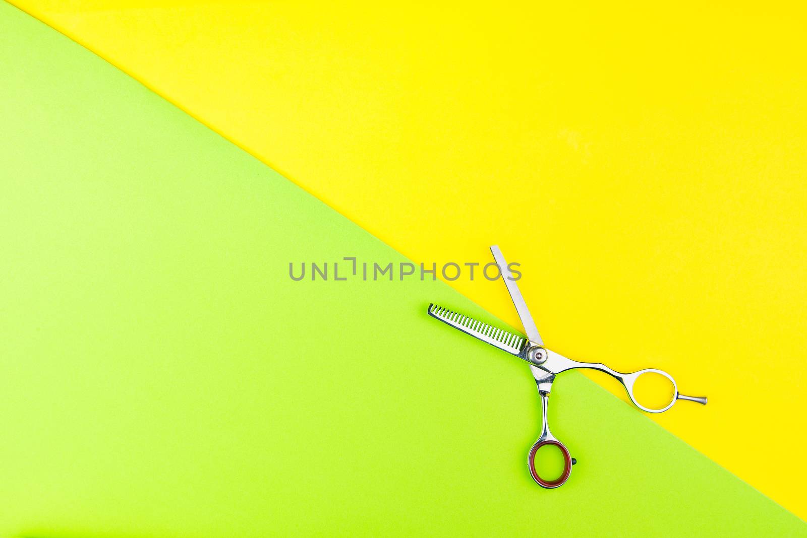 Stylish Professional Barber Scissors on yellow and green background. Hairdresser salon concept, Hairdressing Set. Haircut accessories. Copy space image, flat lay